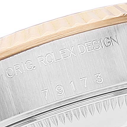 This is a close-up view of the case side of a Rolex Datejust 79173 Women
s Steel and Gold (two tone) White Dial 79173 Women
s Steel and Gold (two tone) White Dial watch, showing the engraving "ORIG. ROLEX DESIGN" and model number "79173."