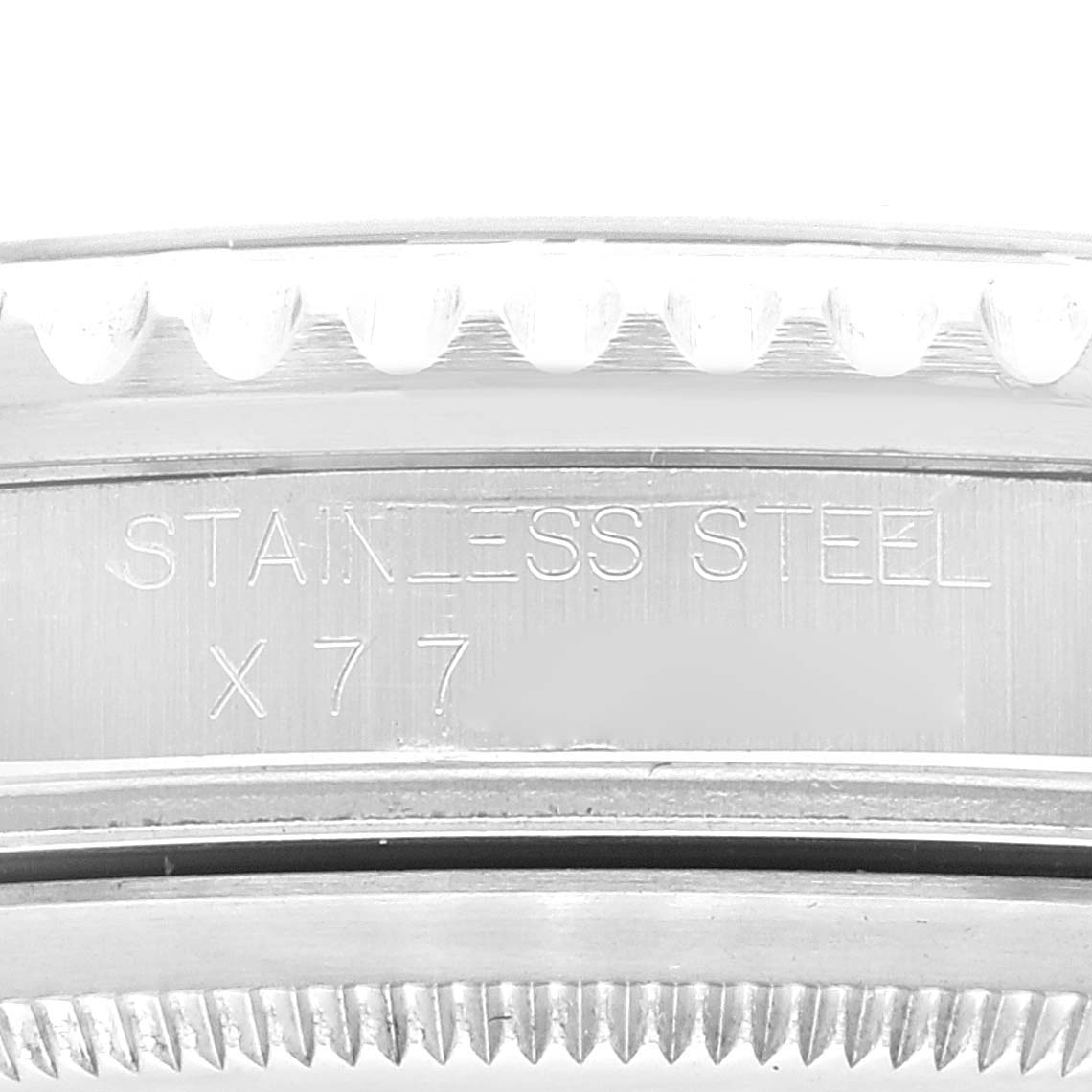 The image shows a close-up of the edge of a stainless steel Rolex GMT-Master 16710 Men
s Stainless Steel Black Dial 16710 Men
s Stainless Steel Black Dial, focusing on the engraved "STAINLESS STEEL X77" marking.