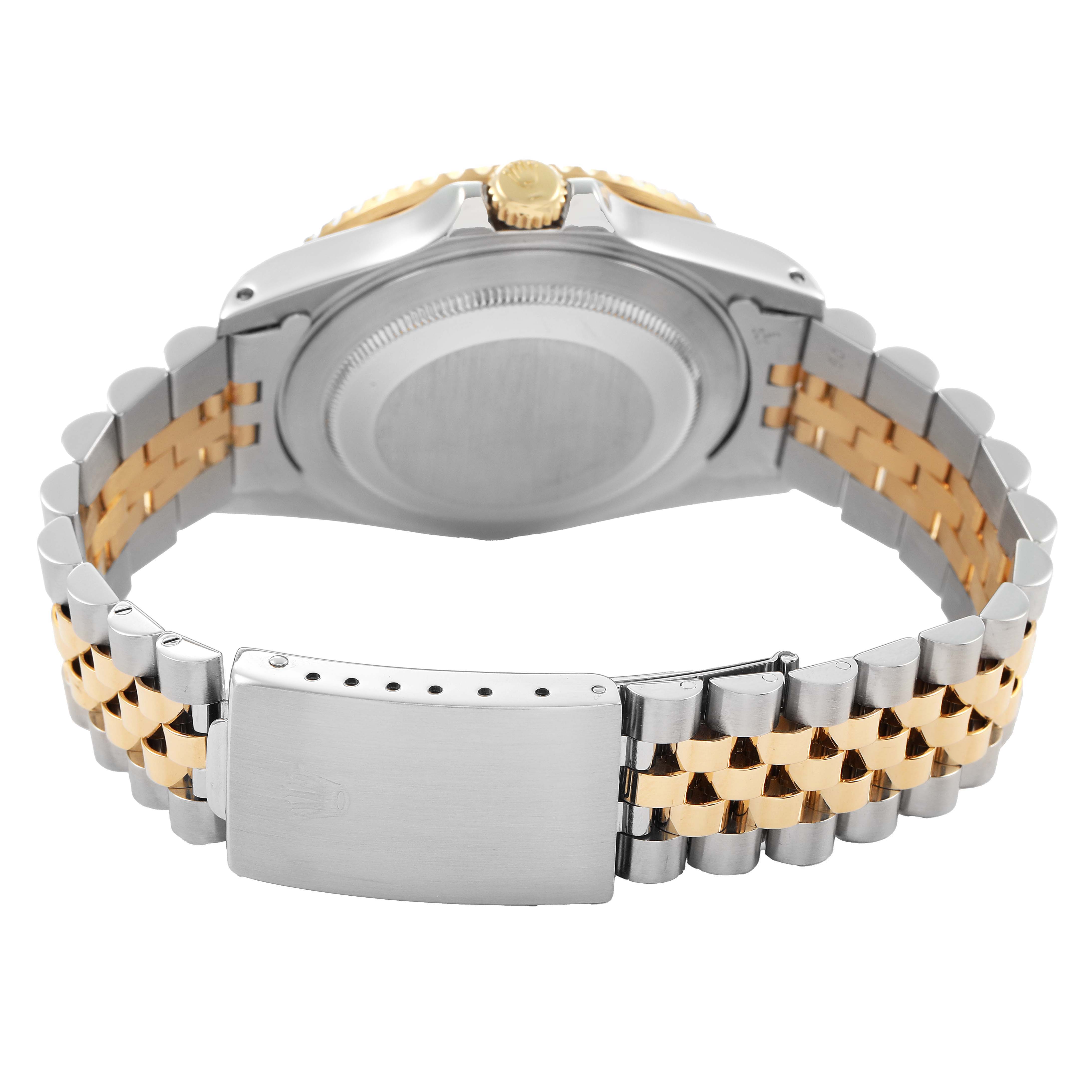The image shows the backside of a Rolex GMT-Master 16713 Men's Steel and Gold (two tone) Black Dial watch focusing on the case, crown, and Jubilee bracelet.