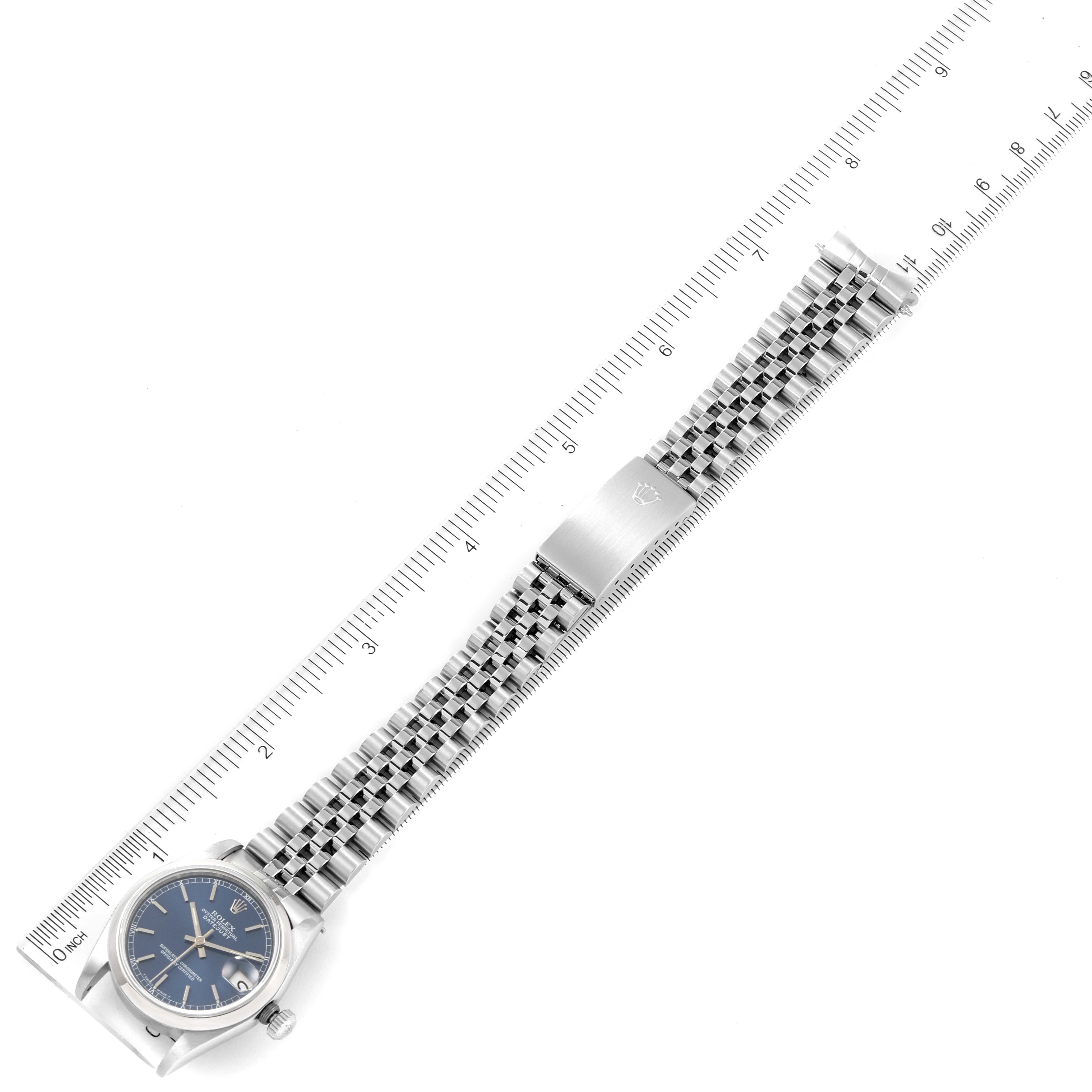 The image shows a top-down view of a Rolex Mid-Size 68240 Women
s Stainless Steel Blue Dial 68240 Women
s Stainless Steel Blue Dial watch with its face, bezel, and bracelet fully displayed beside a ruler for scale.