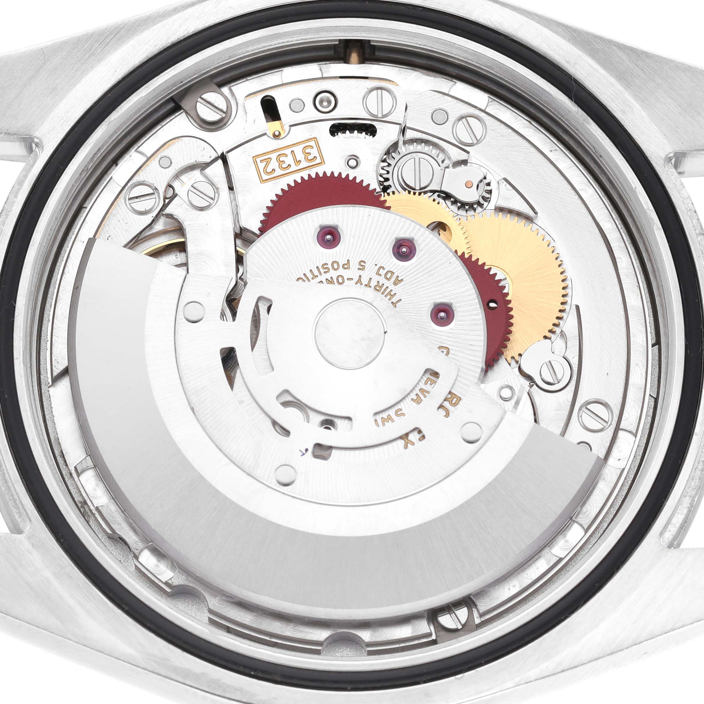The image shows the movement of a Rolex Oyster Perpetual 114300 Men's Stainless Steel Grey Dial watch from a top-down angle, highlighting gears and components.