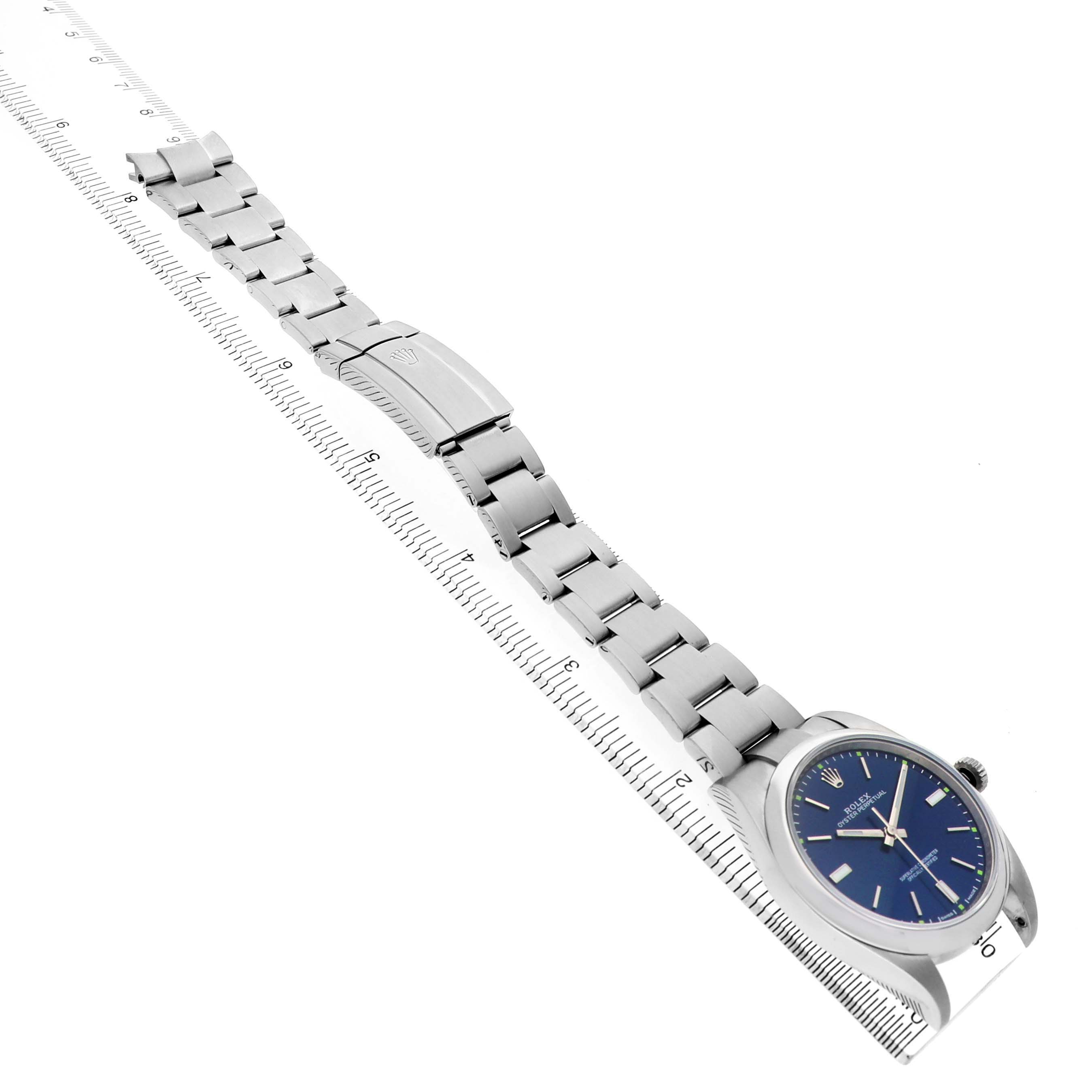 The Rolex Oyster Perpetual 114300 Men's Stainless Steel Blue Dial watch is shown from a top angle with the dial, bracelet, and clasp visible.