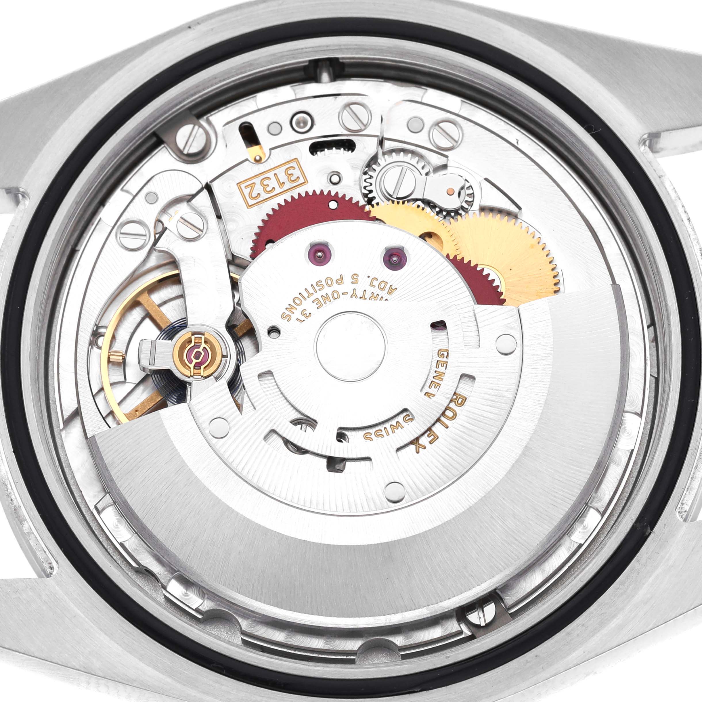 The image shows the internal movement mechanism of a Rolex Oyster Perpetual 114300 Men's Stainless Steel Blue Dial watch from a top-down angle.
