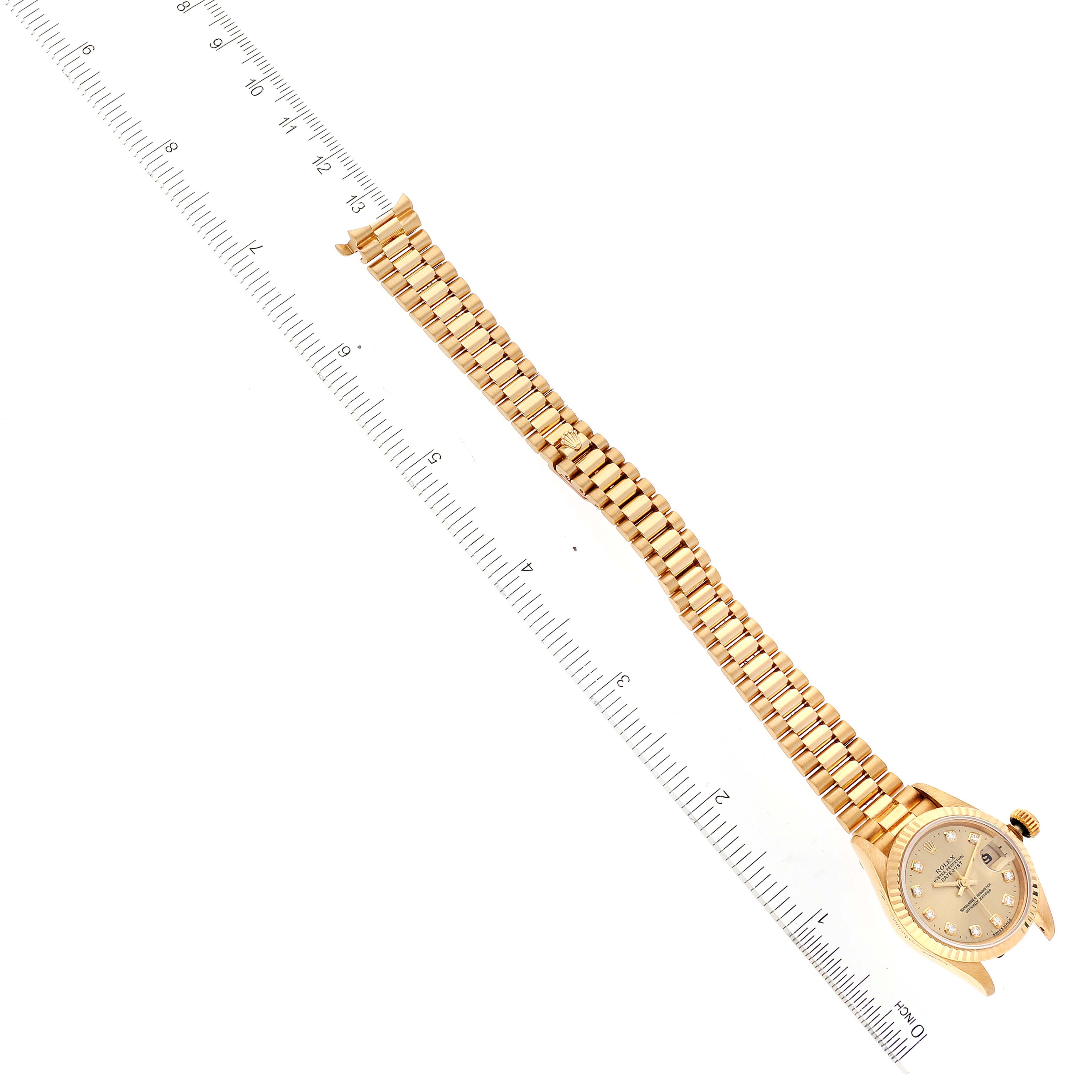 The image shows a Rolex President 69178 Women
s Yellow Gold Champagne Dial 69178 Women
s Yellow Gold Champagne Dial model watch lying flat, with its bracelet extended and aligned next to a measuring ruler.