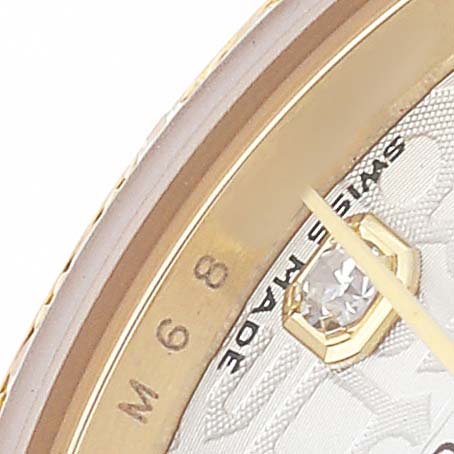The image shows a close-up of the Rolex President 179138 Women's Yellow Gold Silver Dial watch dial, highlighting a gem, part of the bezel, and "Swiss Made" text.