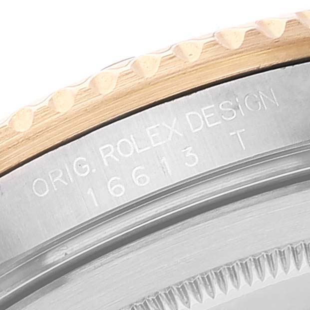 This image shows a close-up view of the bezel and case of a Rolex Submariner 16613 Men's Steel and Gold (two tone) Blue Dial 16613 Men's Steel and Gold (two tone) Blue Dial with the "ORIG. ROLEX DESIGN" and model number 16613 T etched.