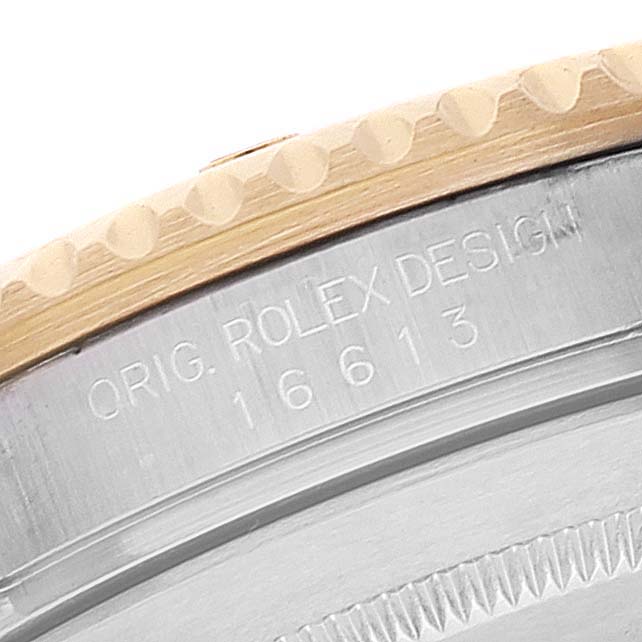 The image shows a close-up of the Rolex Submariner 16613 Men's Steel and Gold (two tone) Blue Dial 16613 Men's Steel and Gold (two tone) Blue Dial model's case with the engraved design and model number.