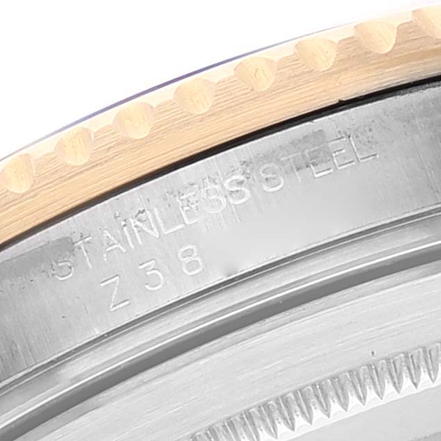 This close-up image shows the edge of the bezel and case of a Rolex Submariner 16613 Men
s Steel and Gold (two tone) Blue Dial 16613 Men
s Steel and Gold (two tone) Blue Dial watch with "STAINLESS STEEL" engraving.