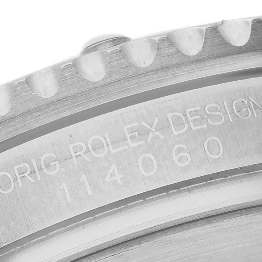 The image shows a close-up of the edge and engraved case back of a Rolex Submariner 114060 Men's Stainless Steel Black Dial watch, highlighting its model number.