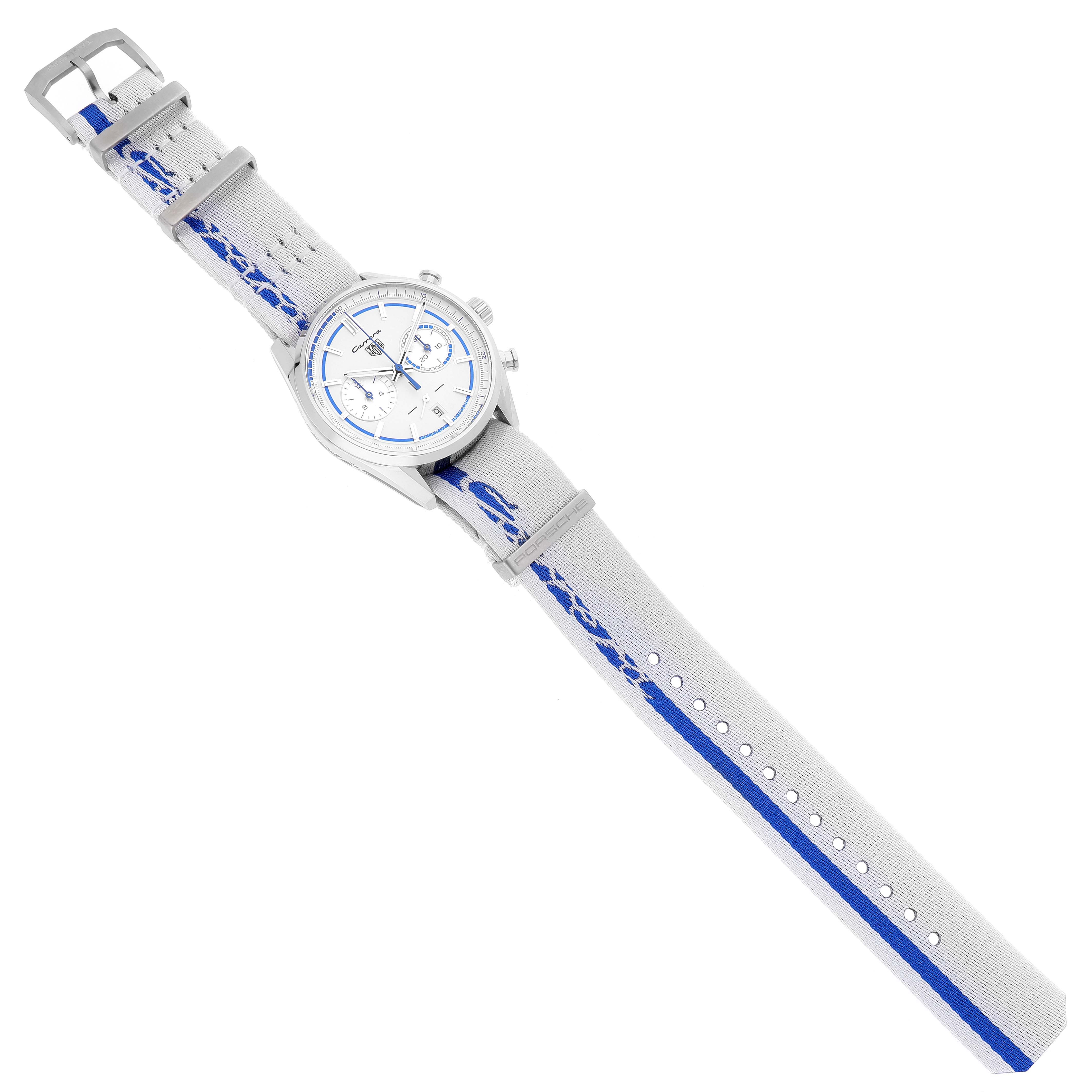The image shows a Tag Heuer Carrera watch from a top-down angle, fully displaying the watch face and both straps with a silver and blue design.