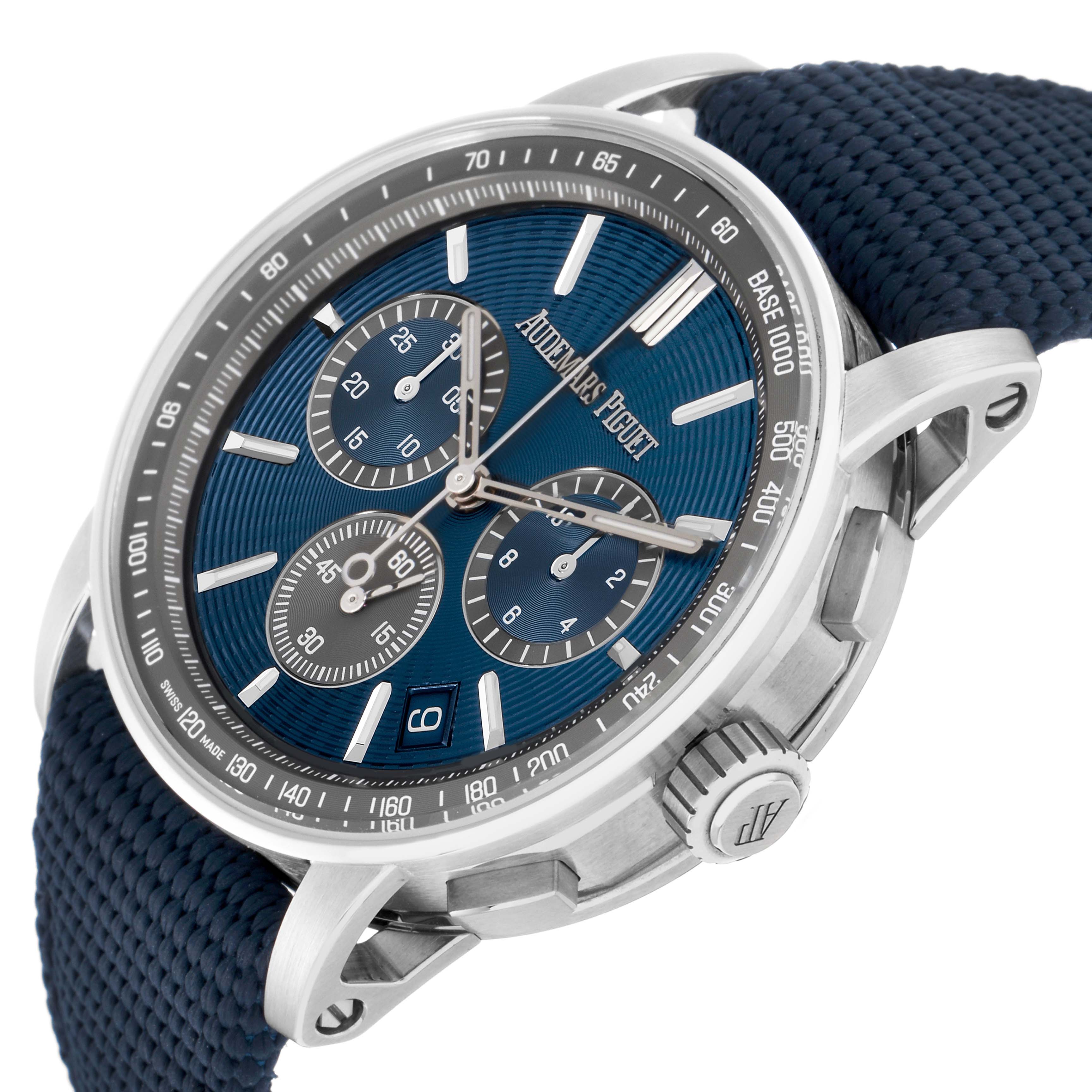 The Jules model by Audemars Piguet is shown at a slight angle, highlighting the blue dial, chronograph subdials, and textured strap.