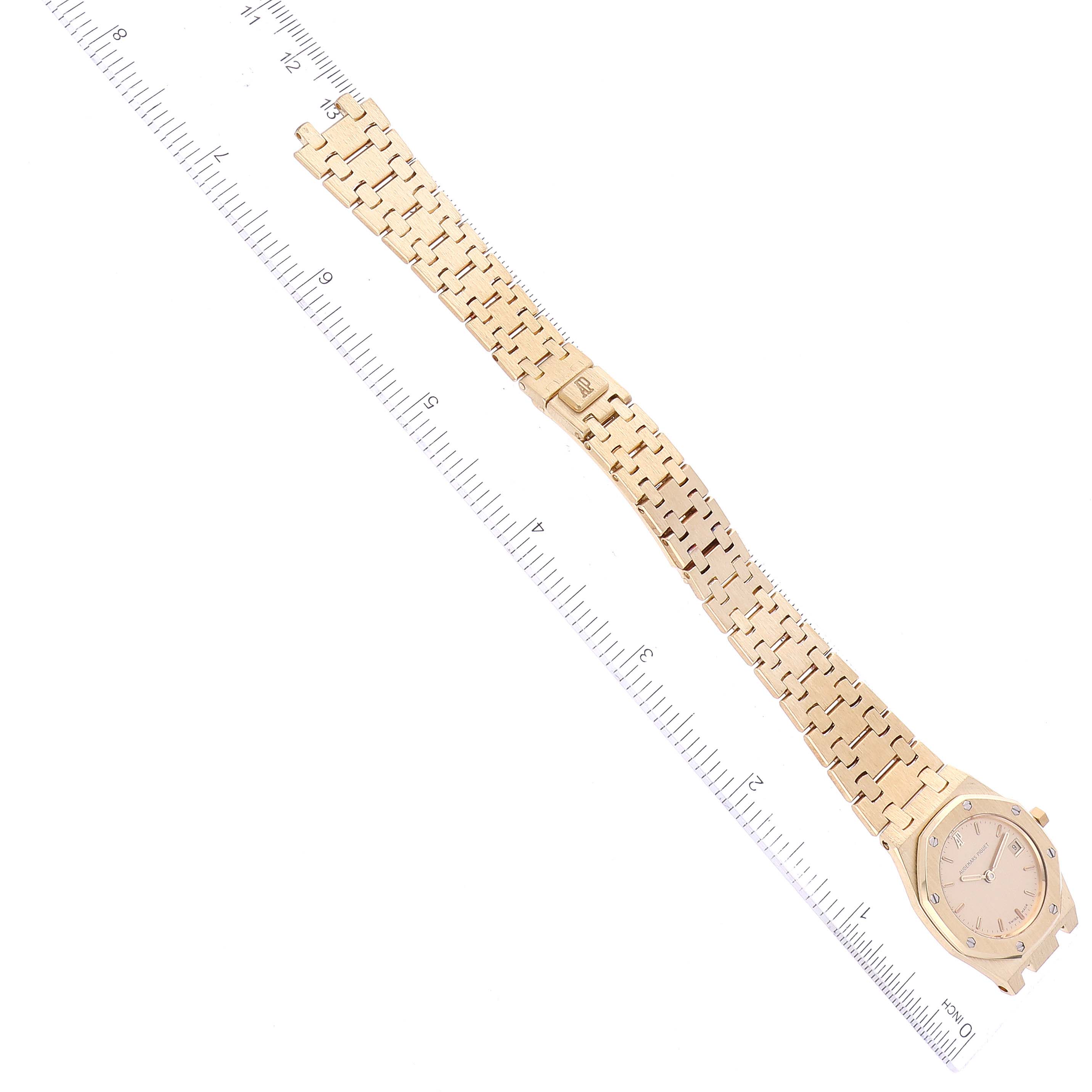 The image shows a top view of a Royal Oak model by Audemars Piguet, including the entire watch and its bracelet alongside a ruler for scale.