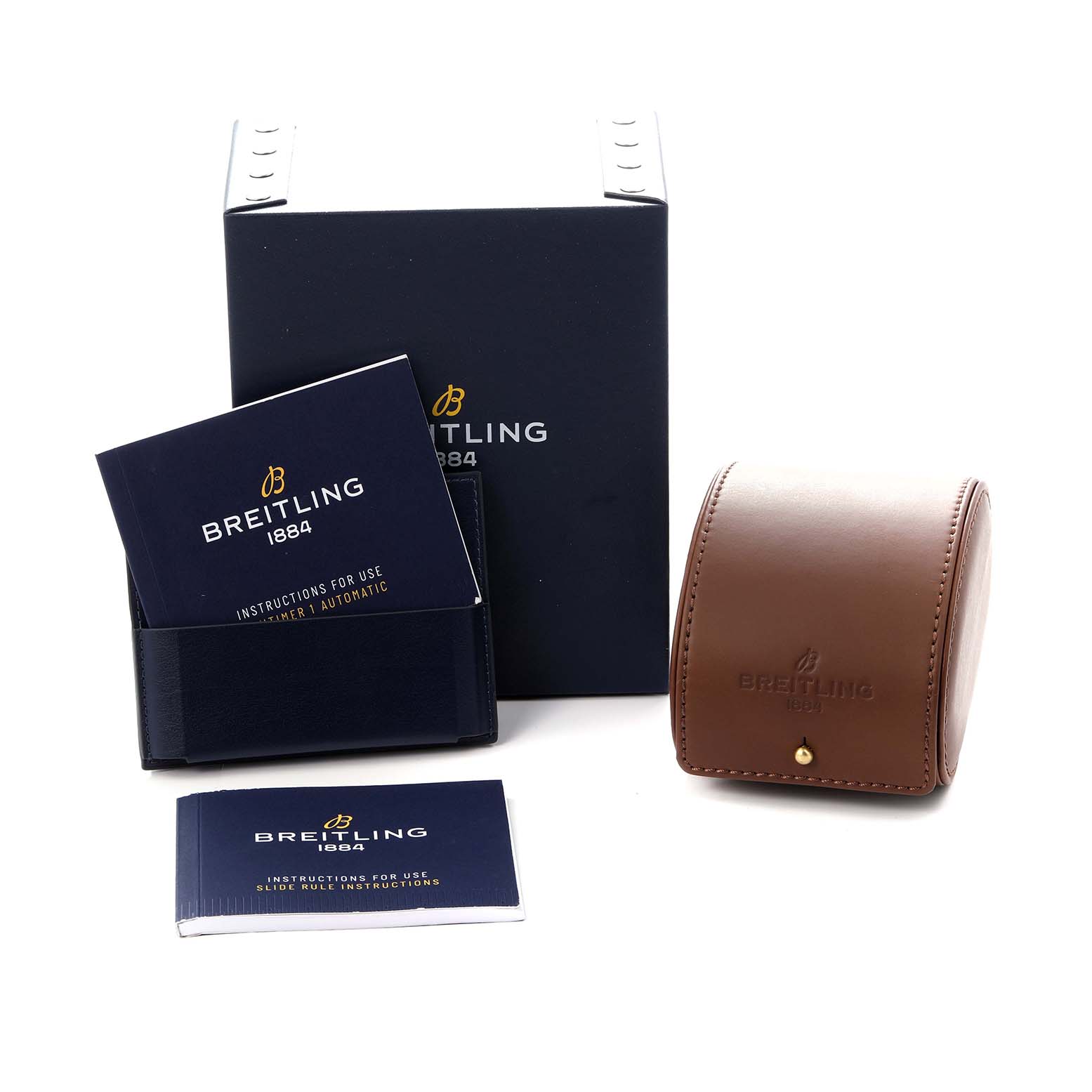 The image shows a Breitling Navitimer A17325 Men
s Stainless Steel Black Dial A17325 Men
s Stainless Steel Black Dial box set, including manuals and a brown leather case, viewed from a front angle.