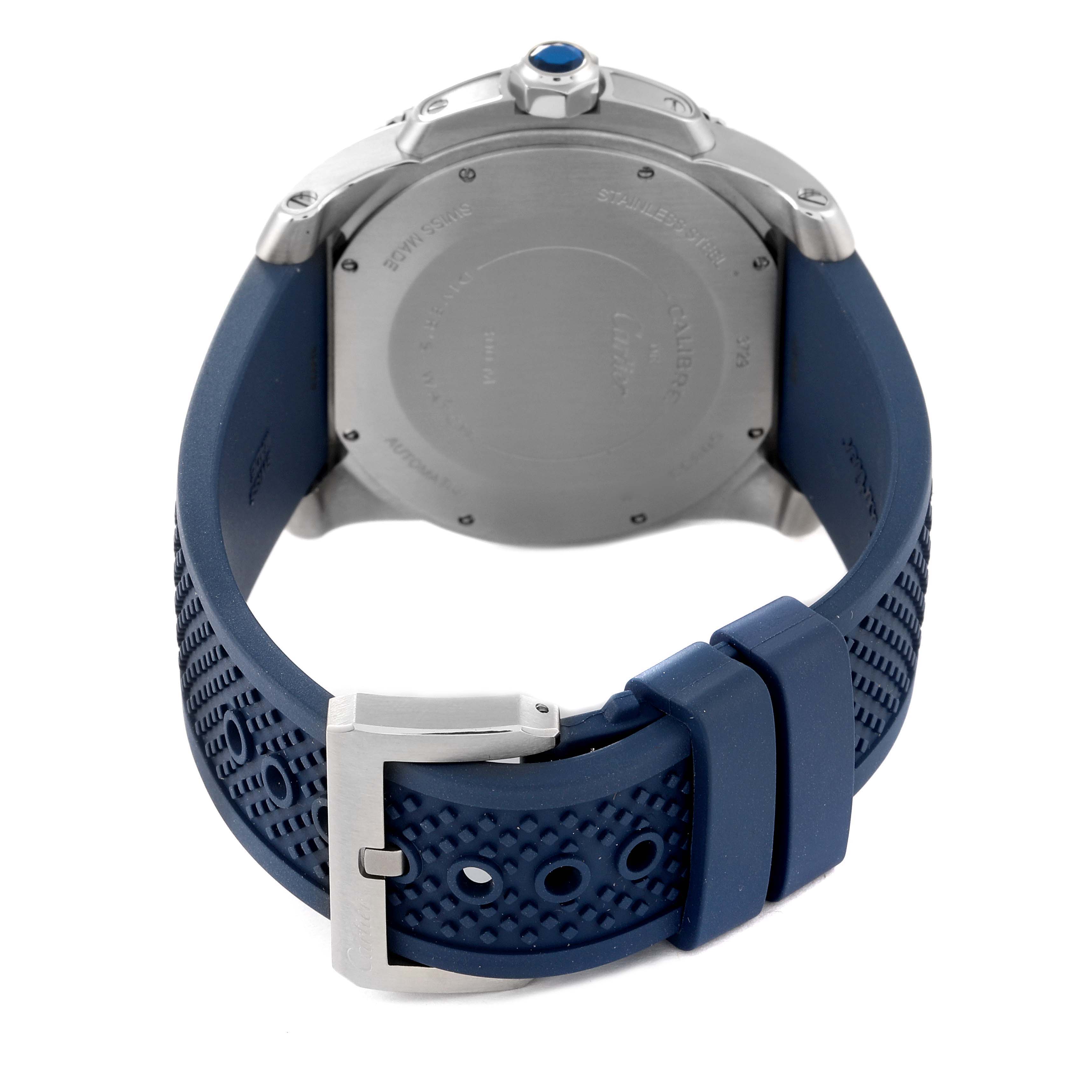 The image shows the back view of a Calibre de Cartier watch by Cartier, highlighting its caseback and blue rubber strap with buckle.