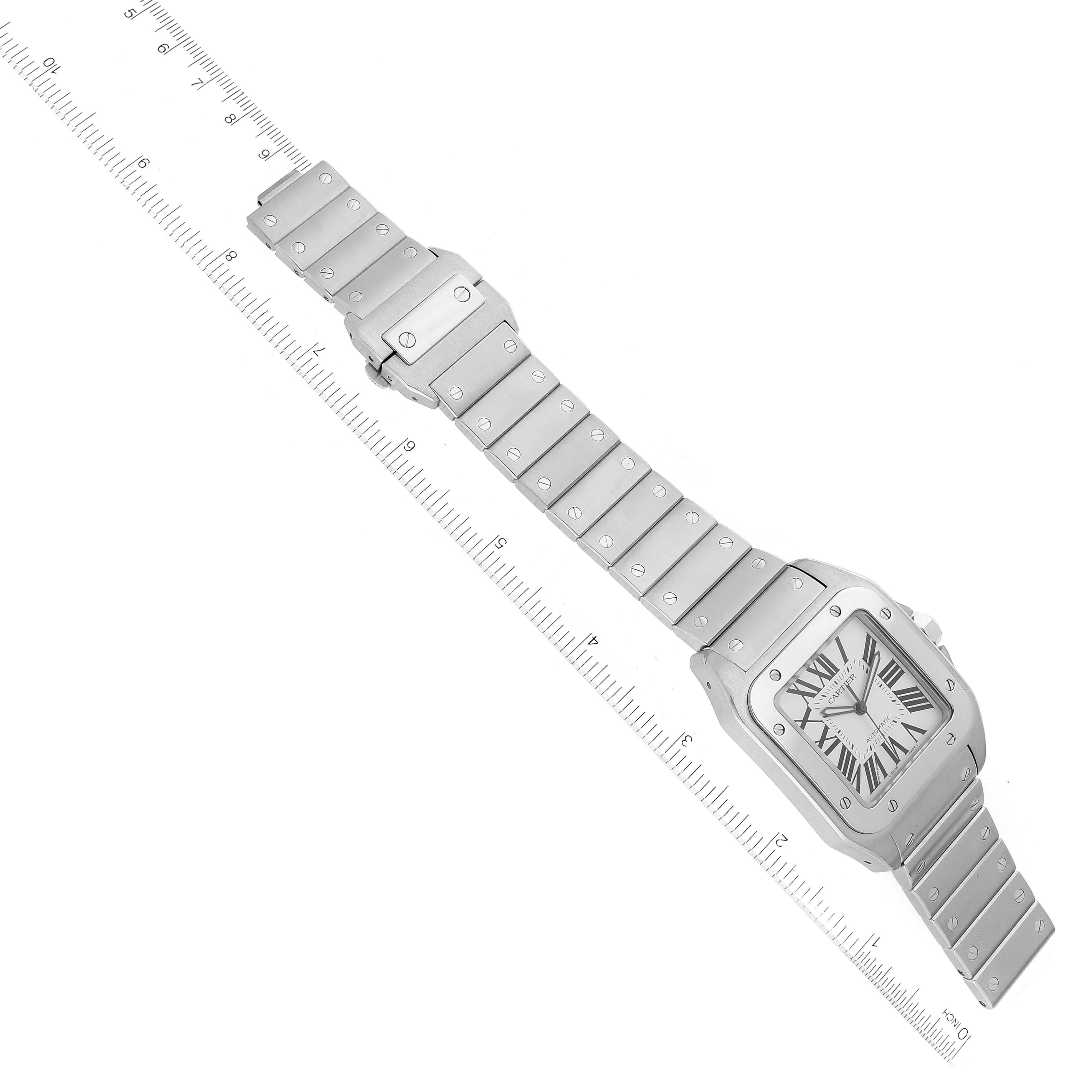 The image shows a Cartier Santos W200737G Men
s Stainless Steel Silver Dial W200737G Men
s Stainless Steel Silver Dial watch laid flat with its face upright, positioned diagonally along with a ruler for measurement.