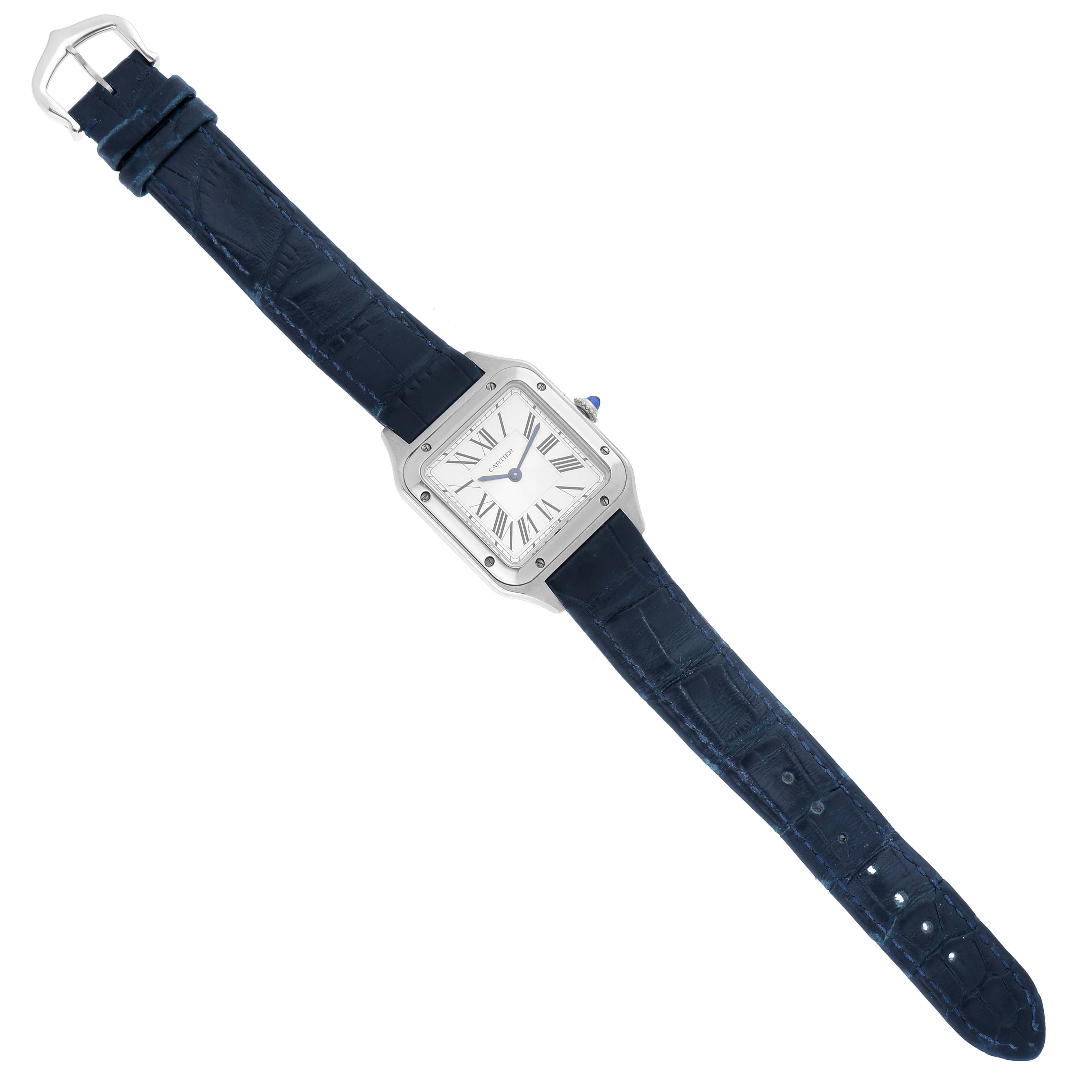 The Cartier Santos WSSA0023 Women
s Stainless Steel Silver Dial WSSA0023 Women
s Stainless Steel Silver Dial watch is shown in a top-down view, with its blue strap and square face prominently displayed.