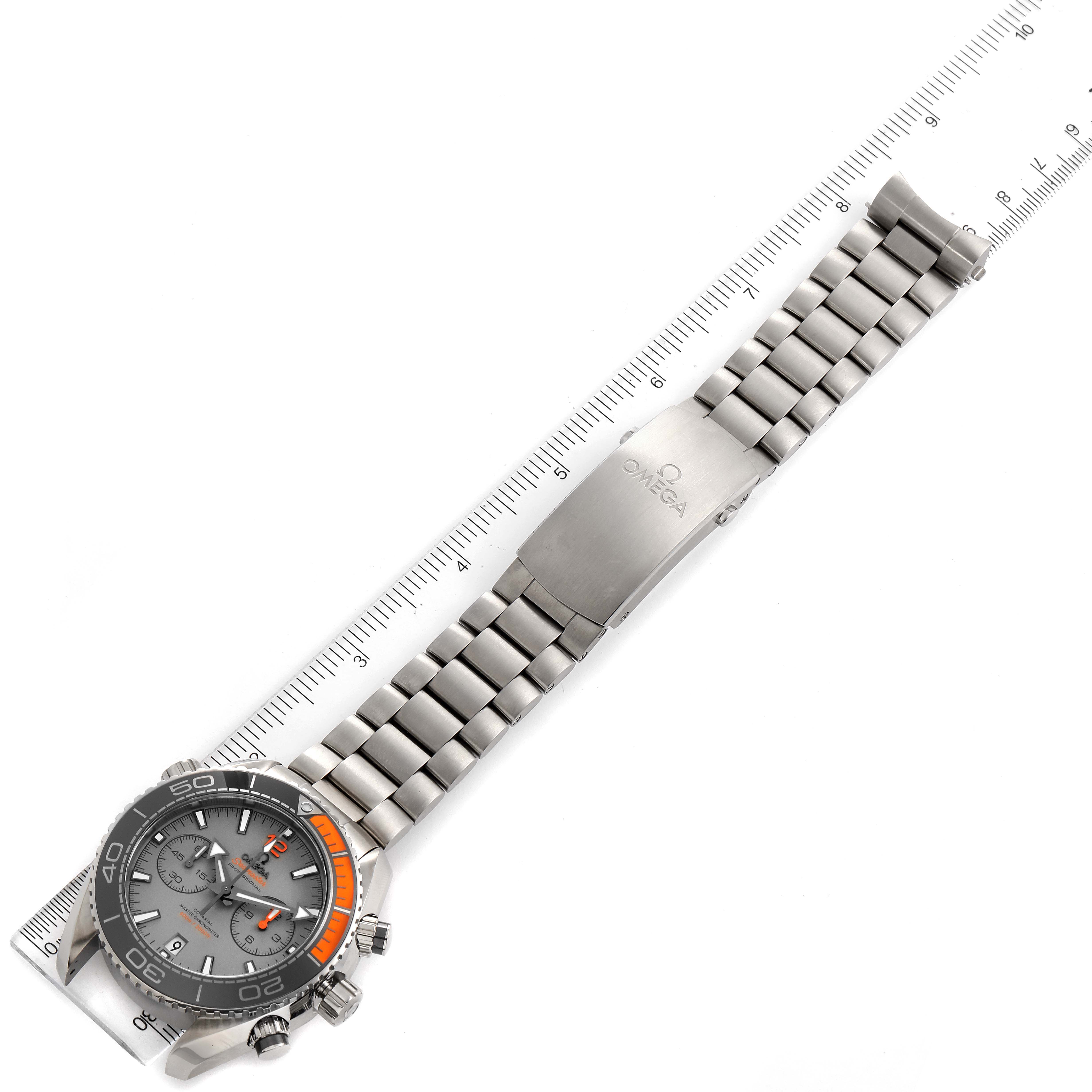 The image shows an Omega Planet Ocean 215.90.46.51.99.001 Men's Titanium Grey Dial 215.90.46.51.99.001 Men's Titanium Grey Dial watch laid flat with its stainless steel bracelet and clasp, next to a ruler for scale.