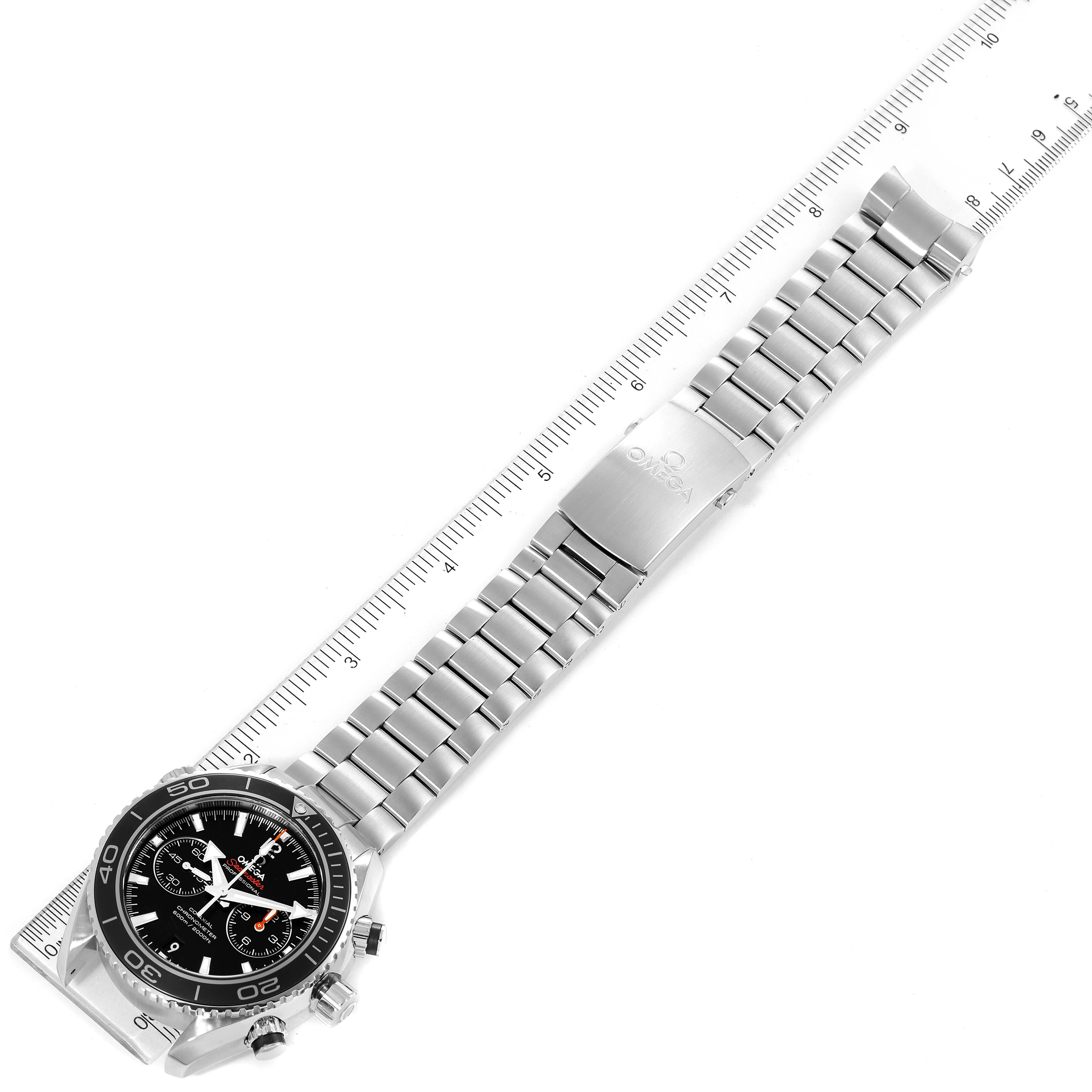 The image shows an Omega Planet Ocean 232.30.46.51.01.001 Men
s Stainless Steel Black Dial 232.30.46.51.01.001 Men
s Stainless Steel Black Dial watch at an aerial angle, highlighting its bracelet, clasp, and dial.