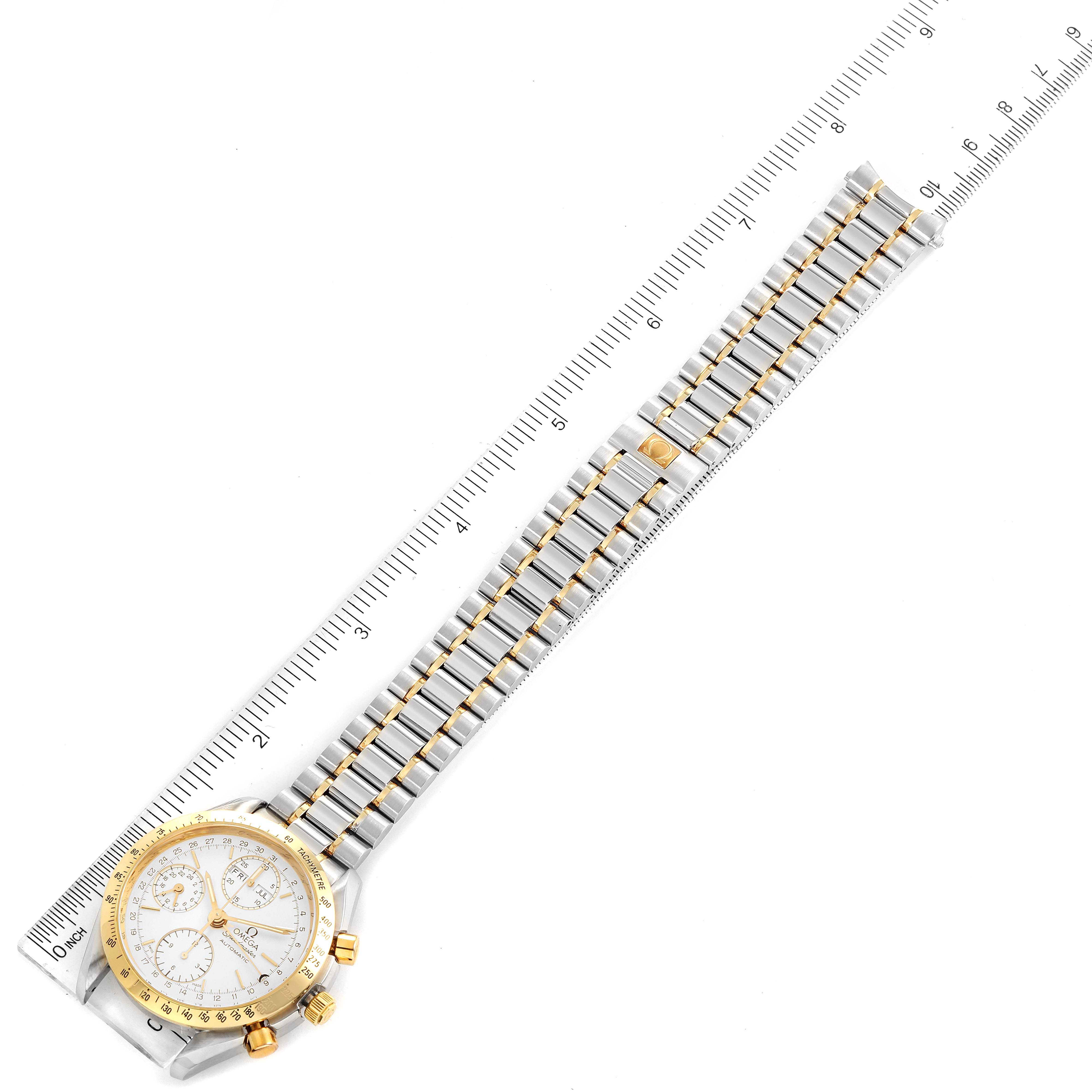 The Omega Speedmaster 3321.30.00 Men's Steel and Gold (two tone) Silver Dial 3321.30.00 Men's Steel and Gold (two tone) Silver Dial watch is shown from a top-down angle, highlighting the face, bezel, and full bracelet laid next to a ruler.