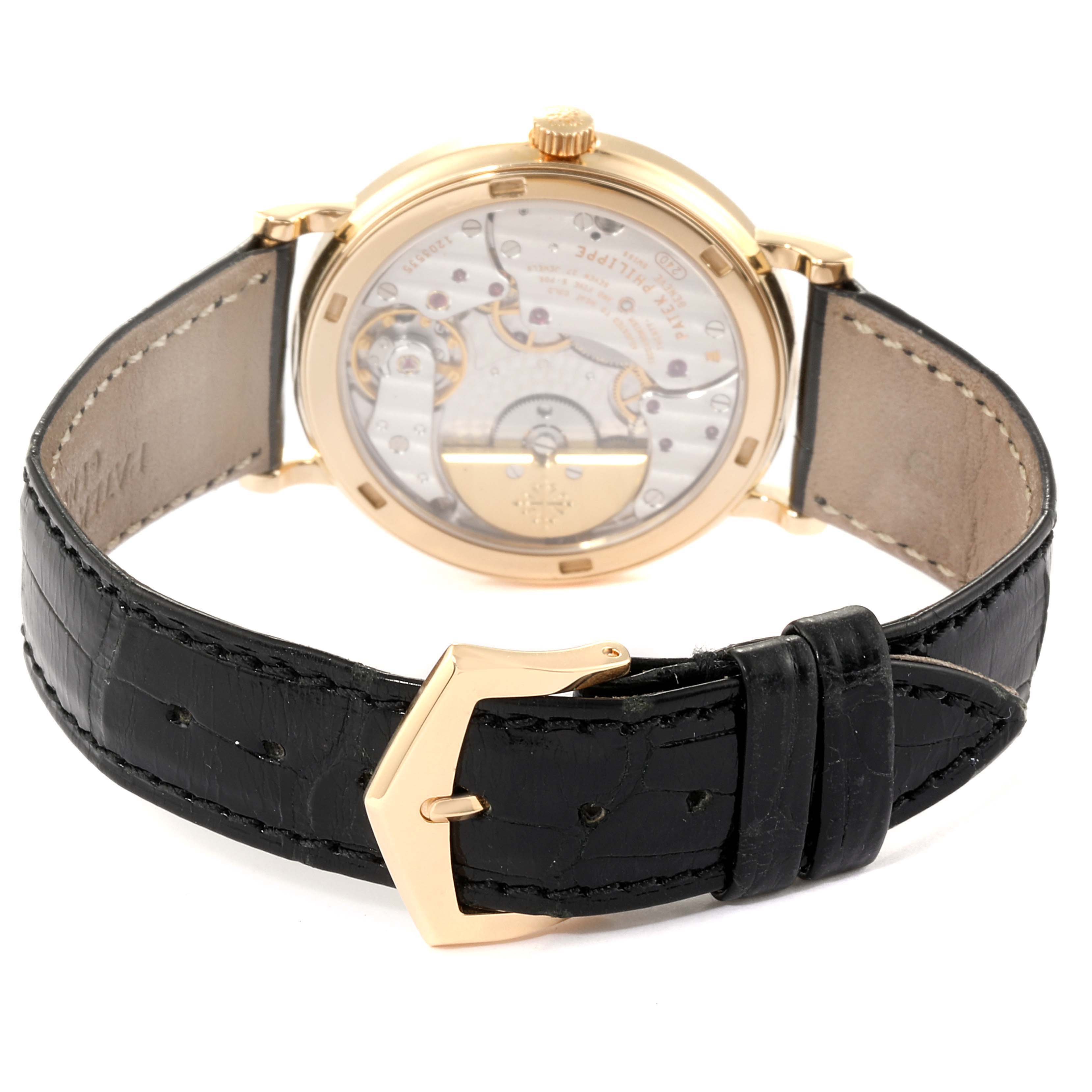 The image shows the back view of a Patek Philippe Calatrava 5120J Men's Yellow Gold White Dial 5120J Men's Yellow Gold White Dial watch, highlighting its movement and black leather strap with a gold buckle.