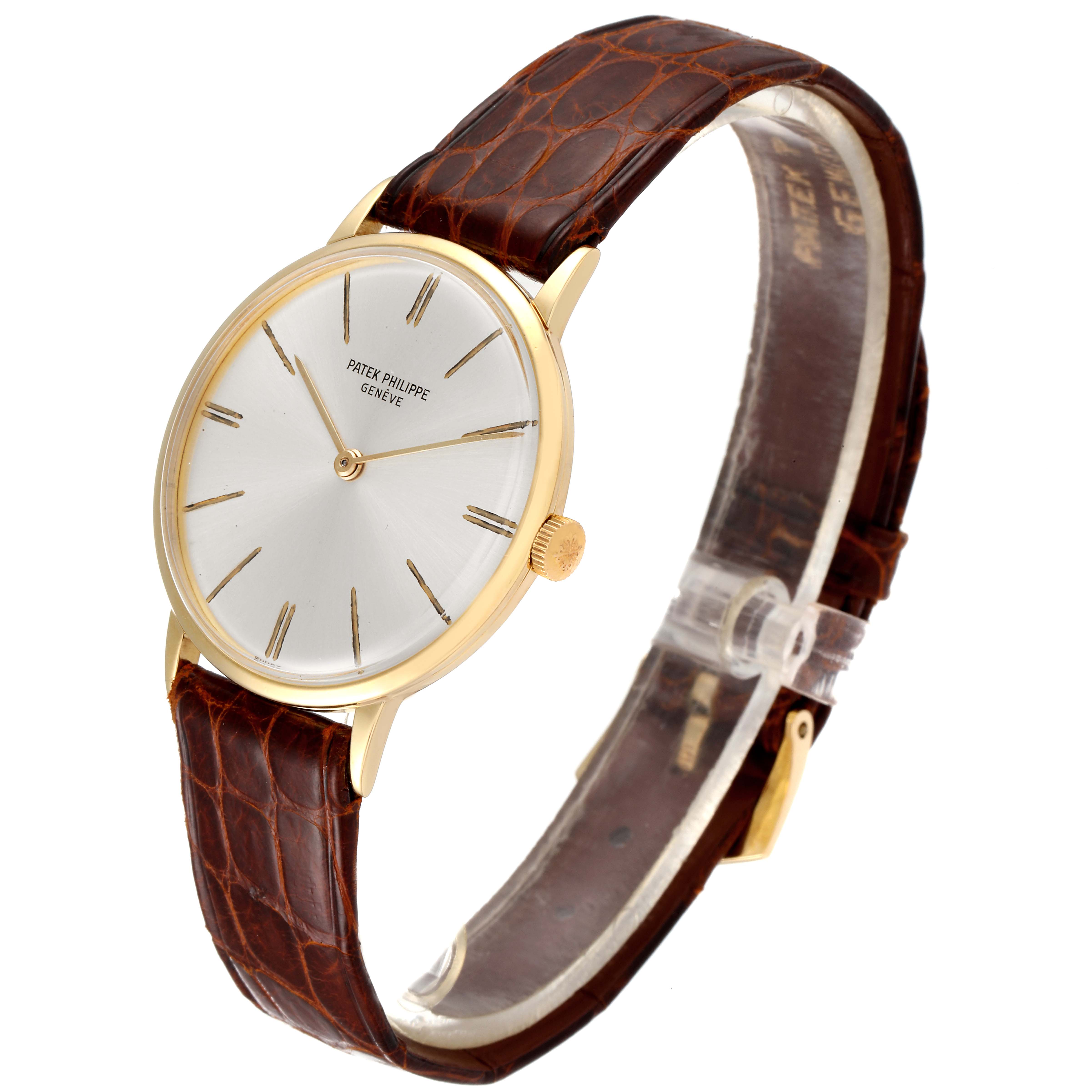 The image shows a Vintage Patek Philippe watch with a gold case, white dial, and brown leather strap viewed from an angle.