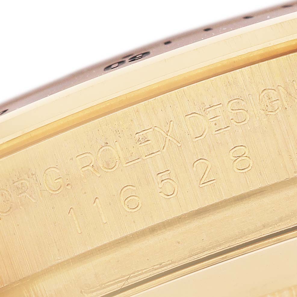The image shows a close-up of the side of a Rolex Daytona 116528 Men's Yellow Gold Champagne Dial, highlighting the engraved serial and model numbers.