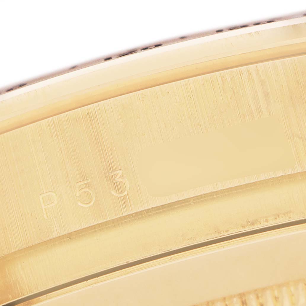 This close-up image shows the engraved side of the bezel on a Rolex Daytona 116528 Men's Yellow Gold Champagne Dial watch.