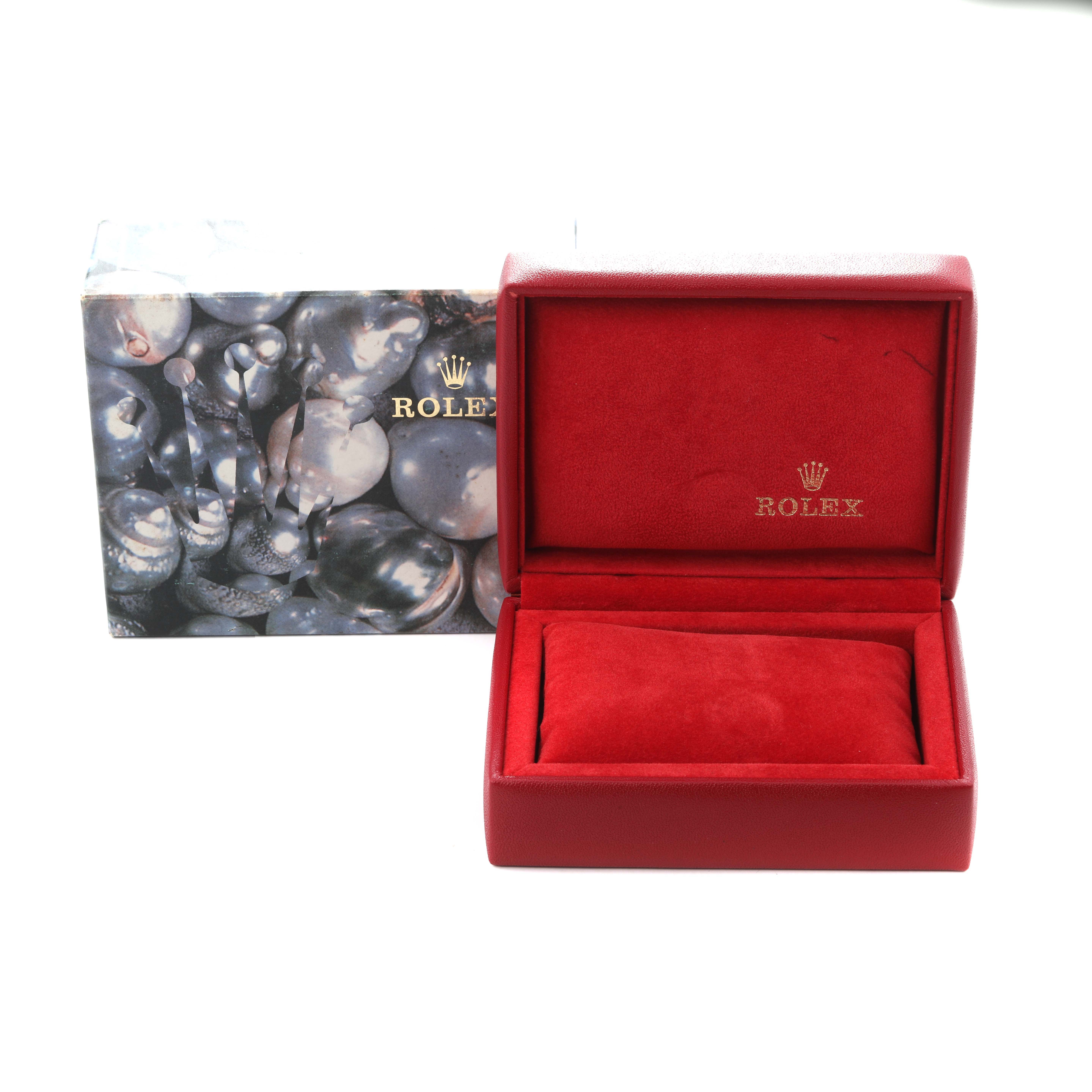 The image shows a red Rolex watch box for the Date model, with the lid open, revealing a padded interior.