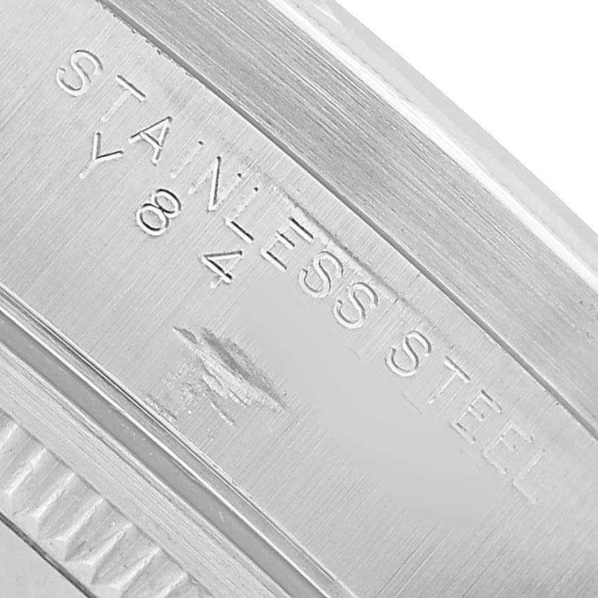 The image shows a close-up of a Rolex Date 15210 Men's Stainless Steel Black Dial model's stainless steel case back, featuring engraved text.