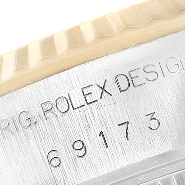 This close-up image shows the model and serial numbers engraved on the side of a Rolex Datejust 69173 Women's Stainless Steel Champagne Dial 69173 Women's Stainless Steel Champagne Dial watch's case under the bezel.