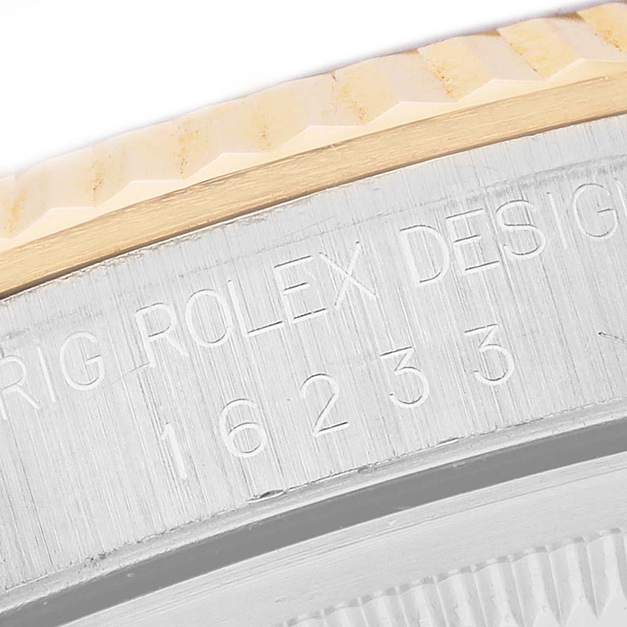 The image shows a close-up of the case and fluted bezel of a Rolex Datejust 16233 Men's Steel and Gold (two tone) Black Dial, highlighting engraved details.