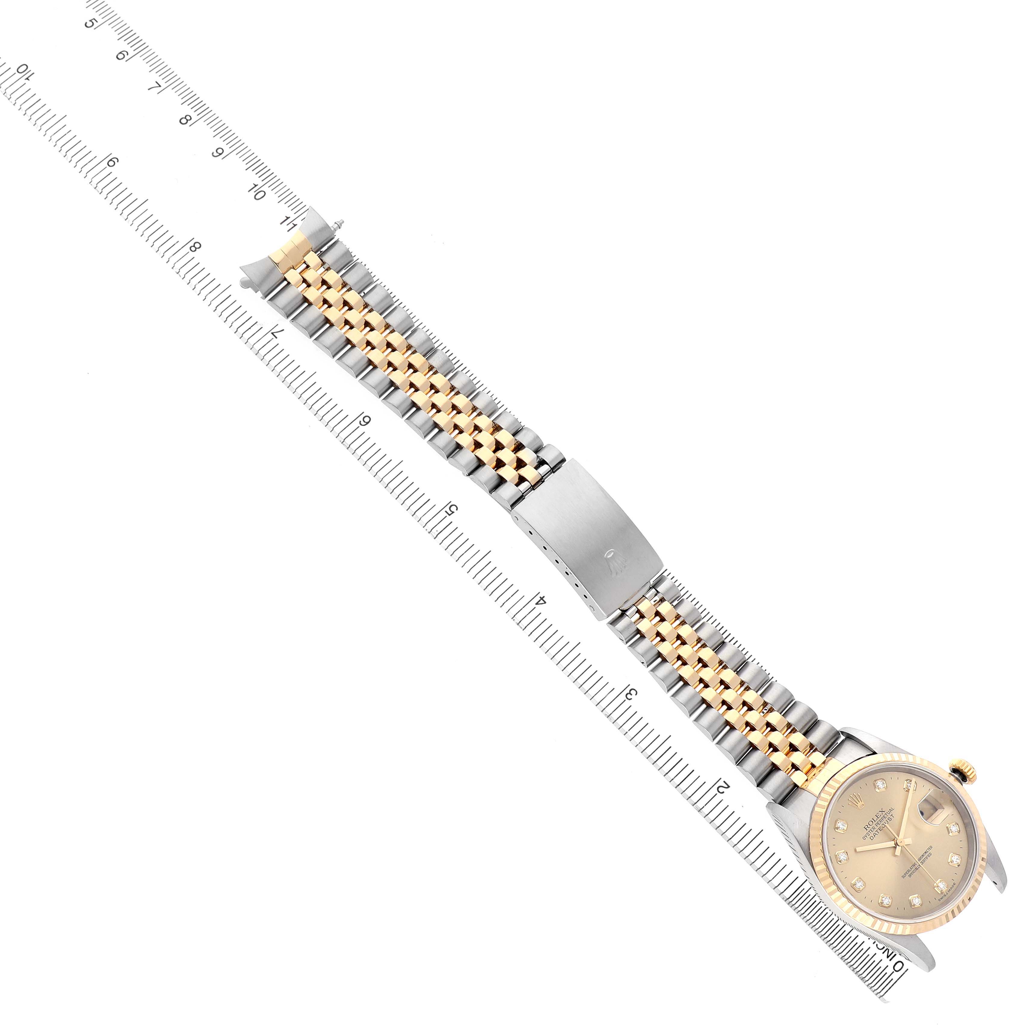 The image shows a Rolex Datejust 16233 Men's Steel and Gold (two tone) Champagne Dial watch from an overhead angle, highlighting the dial, bezel, and two-tone bracelet alongside a ruler.