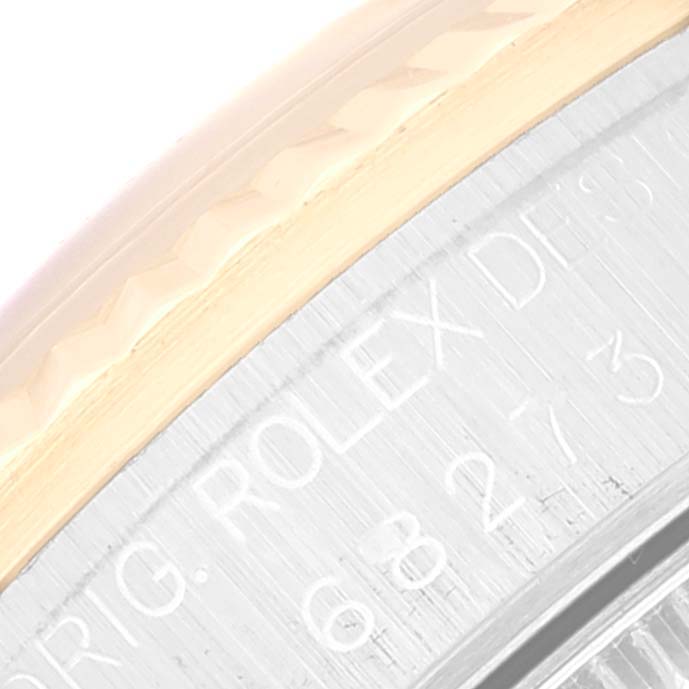 This image shows a close-up of the side of a Mid-Size Rolex watch, focusing on the engraved text on the bezel flange.