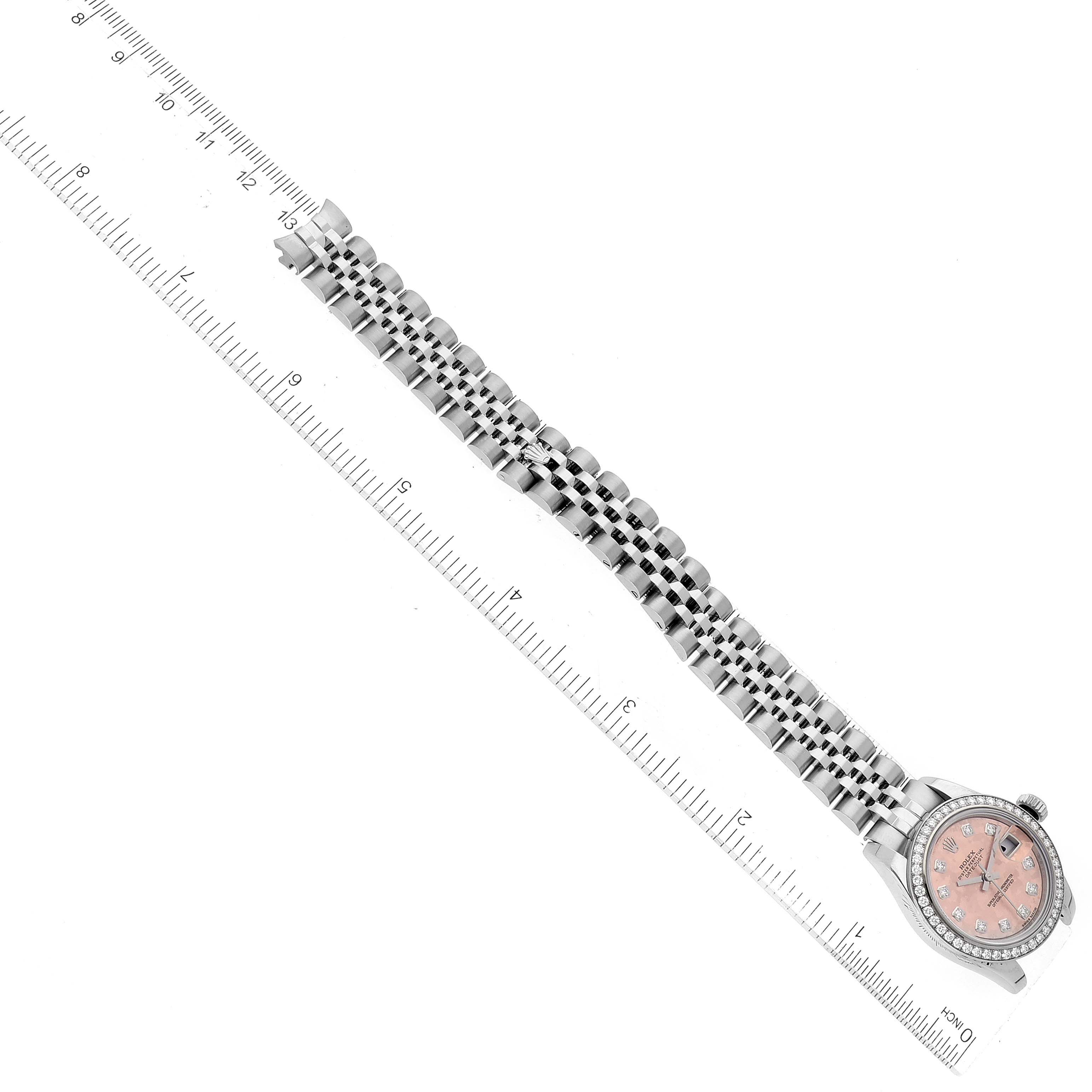 The image shows a top-down view of a Rolex Datejust 179384 Women's Stainless Steel Pink Dial 179384 Women's Stainless Steel Pink Dial watch, featuring the face, bezel, and bracelet alongside a ruler for scale.