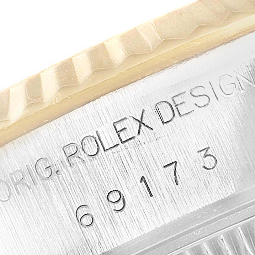 This close-up image shows the Rolex Datejust 69173 Women's Steel and Gold (two tone) Champagne Dial 69173 Women's Steel and Gold (two tone) Champagne Dial model's engraved case with part of the bezel visible.