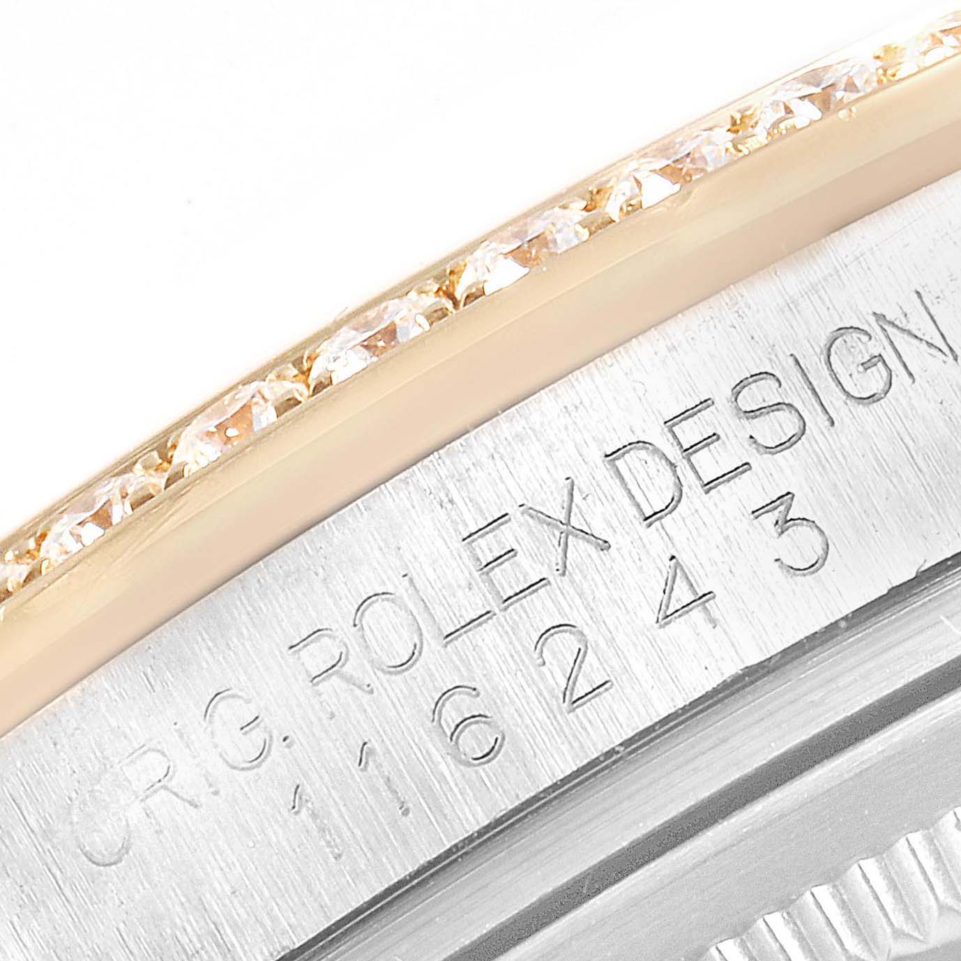 This close-up image of the Rolex Datejust 116243 Men's Steel and Gold (two tone) Champagne Dial 116243 Men's Steel and Gold (two tone) Champagne Dial watch shows part of the bezel adorned with diamonds and the engraved case serial number.