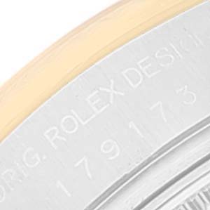 This image shows a close-up of the case back edge of a Rolex Datejust 179173 Women's Steel and Gold (two tone) Black Dial 179173 Women's Steel and Gold (two tone) Black Dial watch, featuring part of the serial number and the "ROLEX DESIGN" engraving.