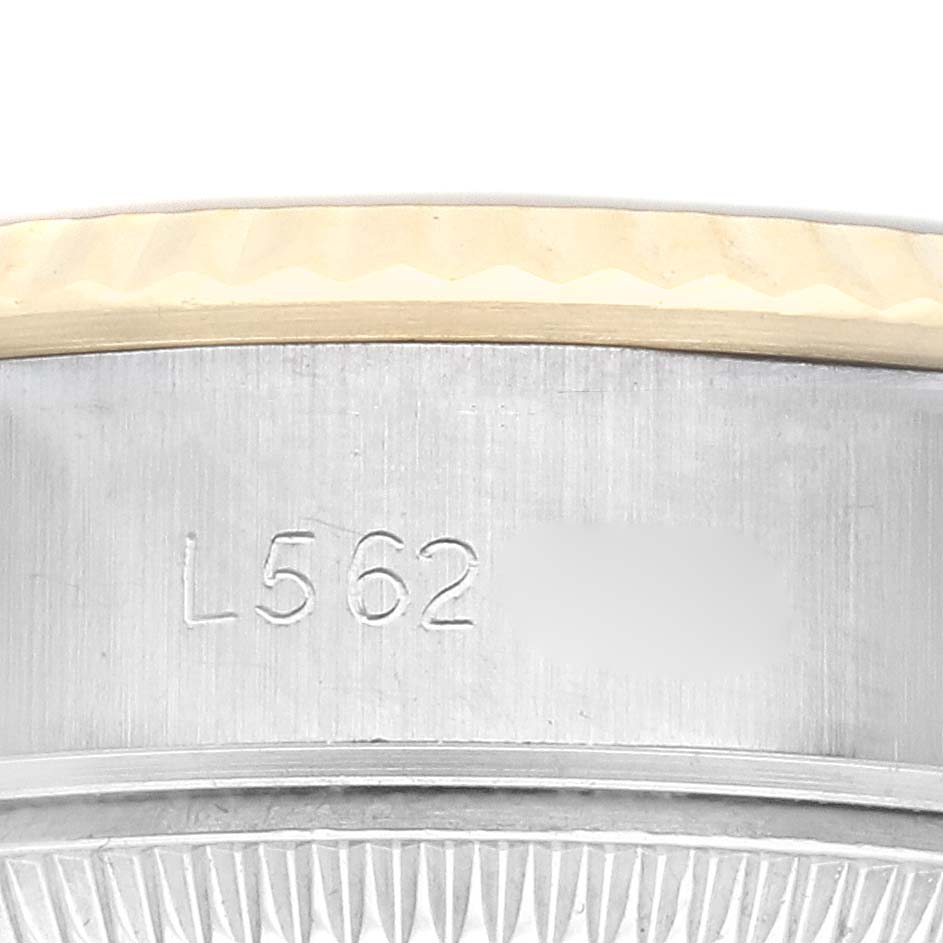 The image shows a close-up of the side of a Rolex Datejust 79173 Women
s Steel and Gold (two tone) Champagne Dial 79173 Women
s Steel and Gold (two tone) Champagne Dial, highlighting the engraved serial number on the case.