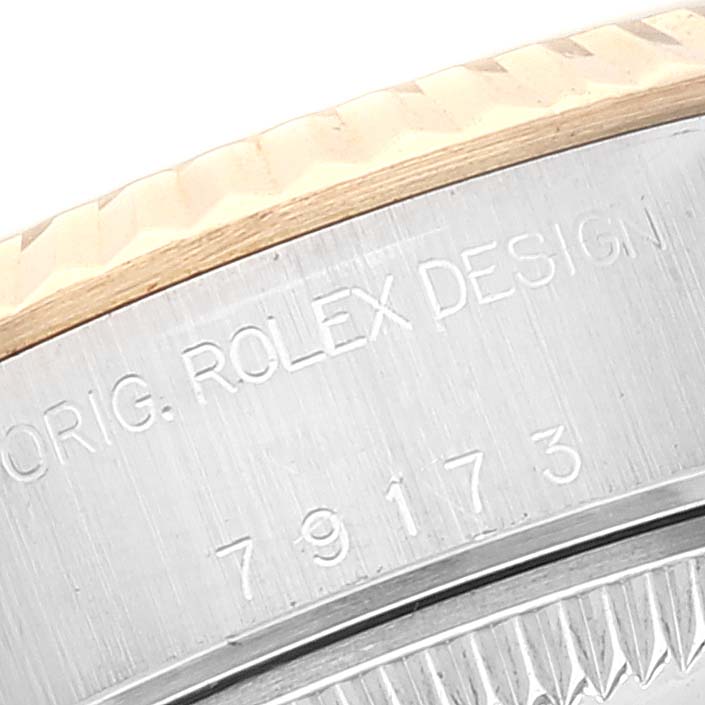 This close-up image shows the serial number and "ROLEX DESIGN" engraving on the side of the Rolex Datejust 79173 Women's Steel and Gold (two tone) Blue Dial 79173 Women's Steel and Gold (two tone) Blue Dial watch case.