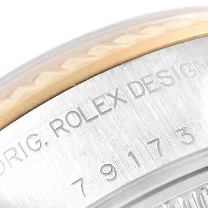 This close-up image shows the engraved case back of a Rolex Datejust 79173 Women
s Steel and Gold (two tone) Champagne Dial 79173 Women
s Steel and Gold (two tone) Champagne Dial watch, highlighting "ROLEX DESIGN" and a portion of the serial number.
