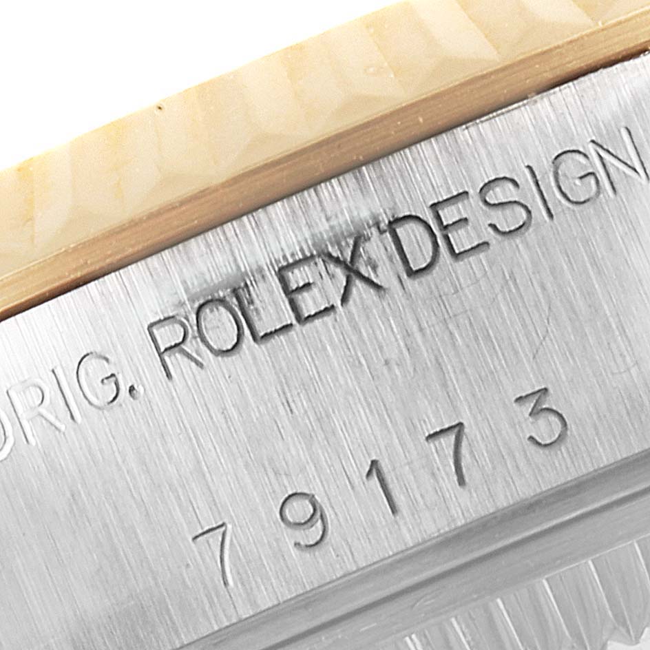 This image shows a close-up of the engraved text on the bezel of a Rolex Datejust 79173 Women's Steel and Gold (two tone) Mother of Pearl Dial 79173 Women's Steel and Gold (two tone) Mother of Pearl Dial watch.
