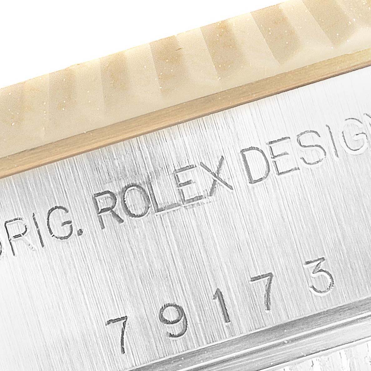The image shows a close-up of the bezel and case side of a Rolex Datejust 79173 Women
s Steel and Gold (two tone) Silver Dial 79173 Women
s Steel and Gold (two tone) Silver Dial watch, highlighting the engraved Rolex design and serial number.
