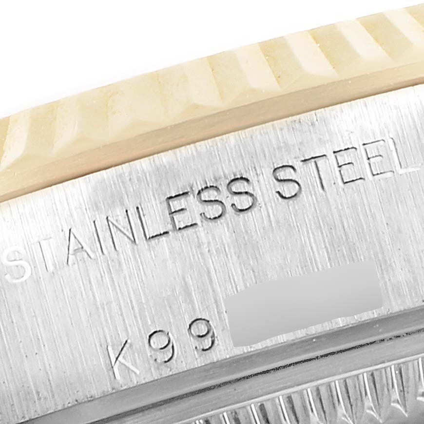 This image shows a close-up of the case side and bezel of a Rolex Datejust 79173 Women
s Steel and Gold (two tone) Silver Dial 79173 Women
s Steel and Gold (two tone) Silver Dial model with an engraving reading "STAINLESS STEEL."