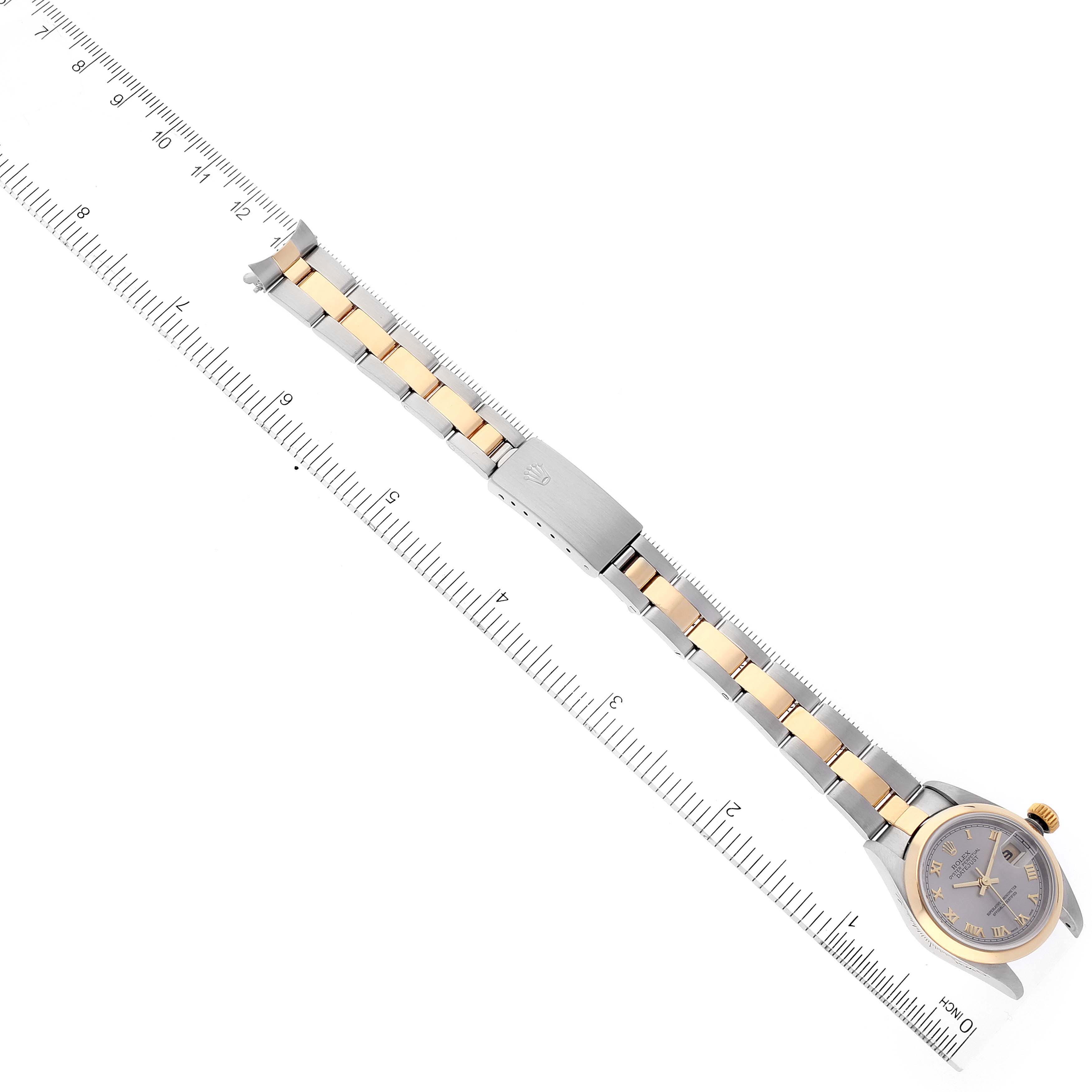 This Rolex Datejust 79163 Women's Steel and Gold (two tone) Grey Dial 79163 Women's Steel and Gold (two tone) Grey Dial watch is shown from a top-down angle, displaying the dial, bracelet, and clasp, positioned along a ruler.