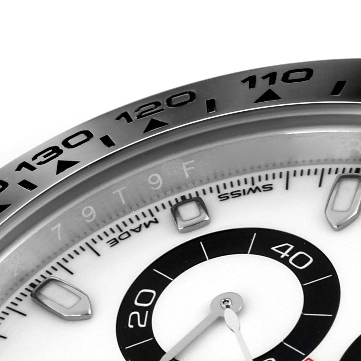 The image shows a close-up of the Rolex Daytona 116500LN Men
s Stainless Steel White Dial 116500LN Men
s Stainless Steel White Dial
s bezel, chapter ring, and part of the dial with an angled side view.