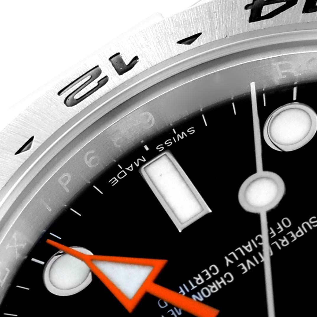 Close-up of the Rolex Explorer 216570 Men
s Stainless Steel Black Dial 216570 Men
s Stainless Steel Black Dial watch showing part of the dial, hands, and bezel with the 12 o’clock marker visible.