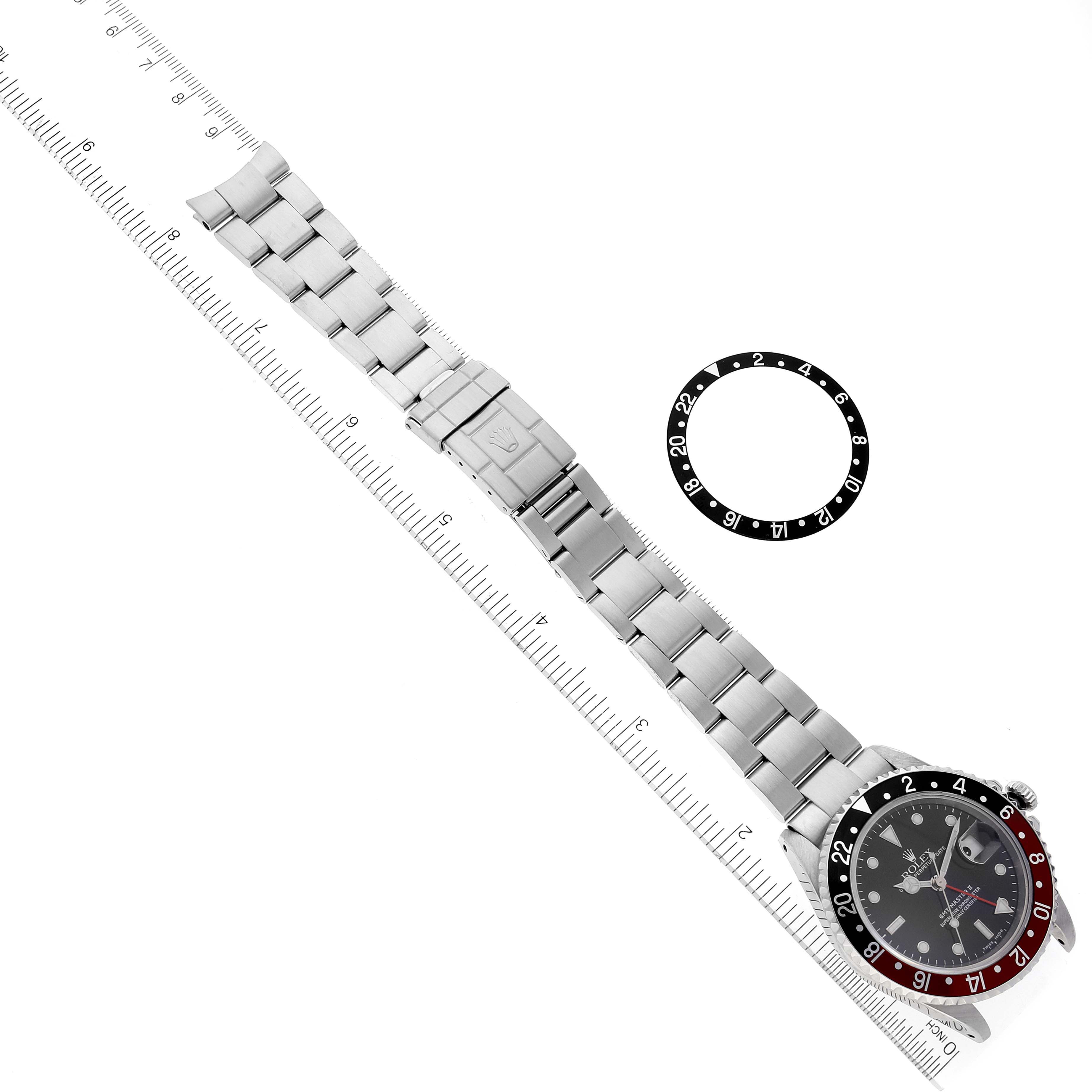 The image shows a Rolex GMT-Master 16710 Men
s Stainless Steel Black Dial 16710 Men
s Stainless Steel Black Dial watch lying flat next to a ruler, with a separate black-and-white 24-hour bezel.