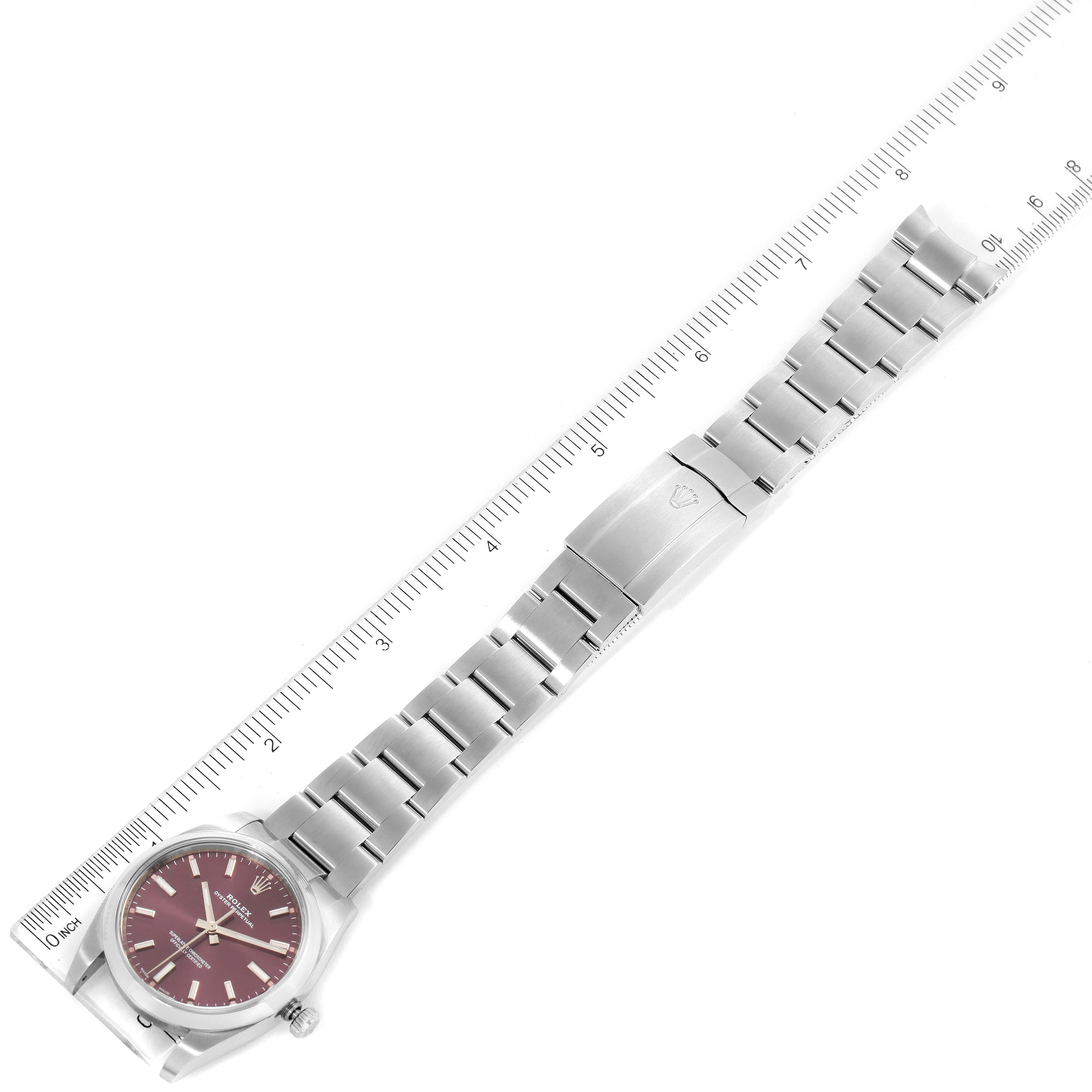 The image shows a Rolex Oyster Perpetual 114200 Men's Stainless Steel Burgundy Dial 114200 Men's Stainless Steel Burgundy Dial watch laid flat, with a ruler next to it for measurement.