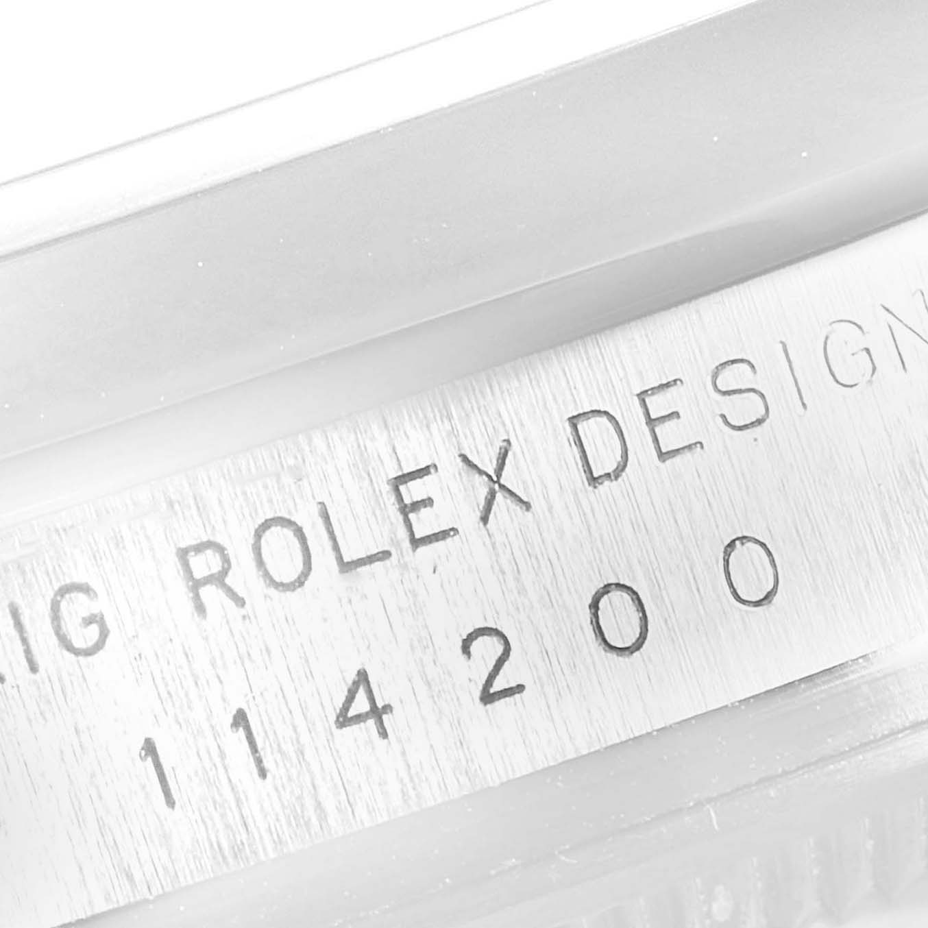 This image shows the serial number engraving on the side of a Rolex Oyster Perpetual 114200 Men's Stainless Steel Burgundy Dial 114200 Men's Stainless Steel Burgundy Dial watch case.