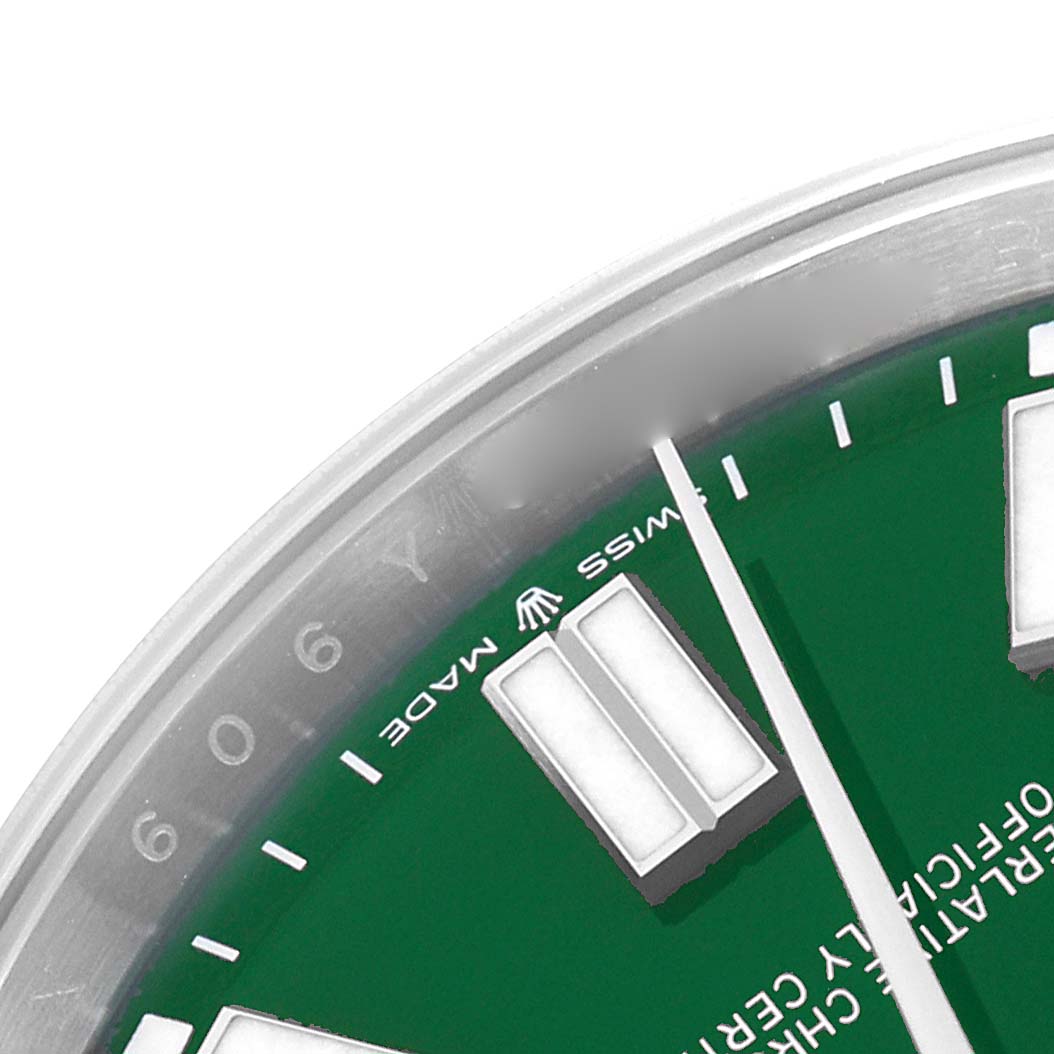 The image shows a close-up of a Rolex Oyster Perpetual 124300 Men
s Stainless Steel Green Dial 124300 Men
s Stainless Steel Green Dial watch face, highlighting the green dial, markers, and part of the bezel.